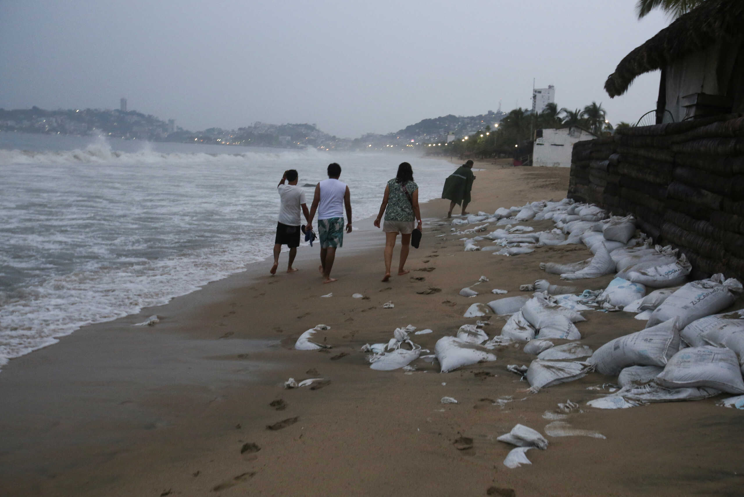 People walk along a beach as Hurricane Otis barrels towards Acapulco, Mexico, October 24, 2023. REUTERS