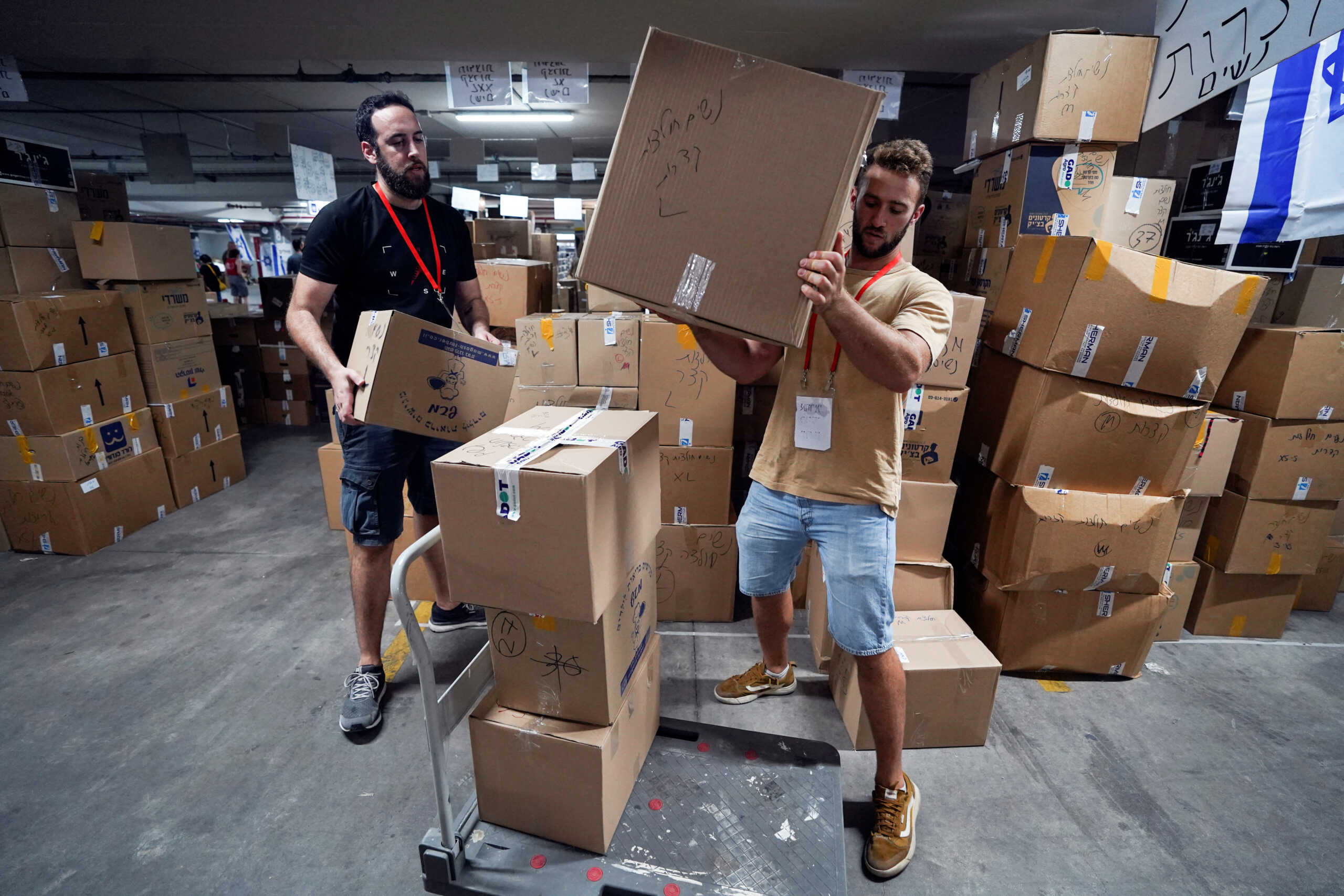Volunteers move boxes of donated humanitarian supplies at a logistical centre of the 'Brothers in Arms' reservist protest group to support those impacted by the deadly infiltration by Hamas gunmen from the Gaza Strip, in Tel Aviv, Israel October 16, 2023. REUTERS