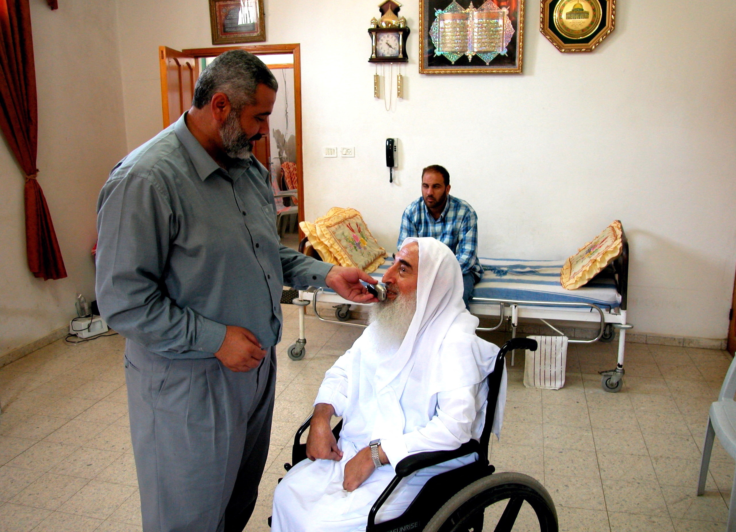 FILE PHOTO: Palestinian Hamas official Ismail Haniyeh assists Hamas co-founder Ahmed Yassin in taking a phone call in Gaza City, Palestinian Territories June 13, 2003. Picture taken June 13, 2003. REUTERS
