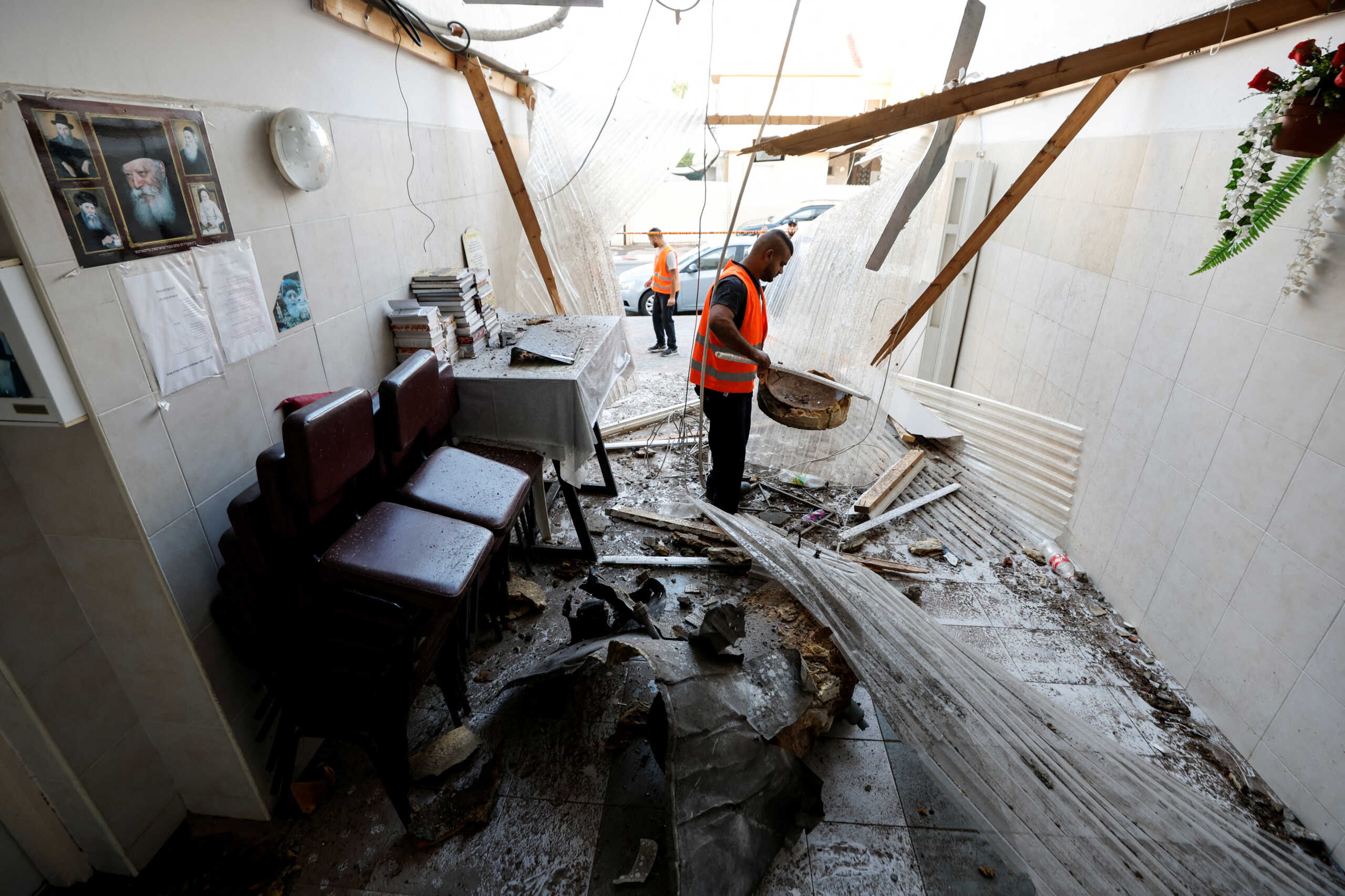 A man clears items at a synagogue that was hit by a rocket launched from the Gaza Strip into Israel, in Ashkelon, southern Israel October 15, 2023. REUTERS