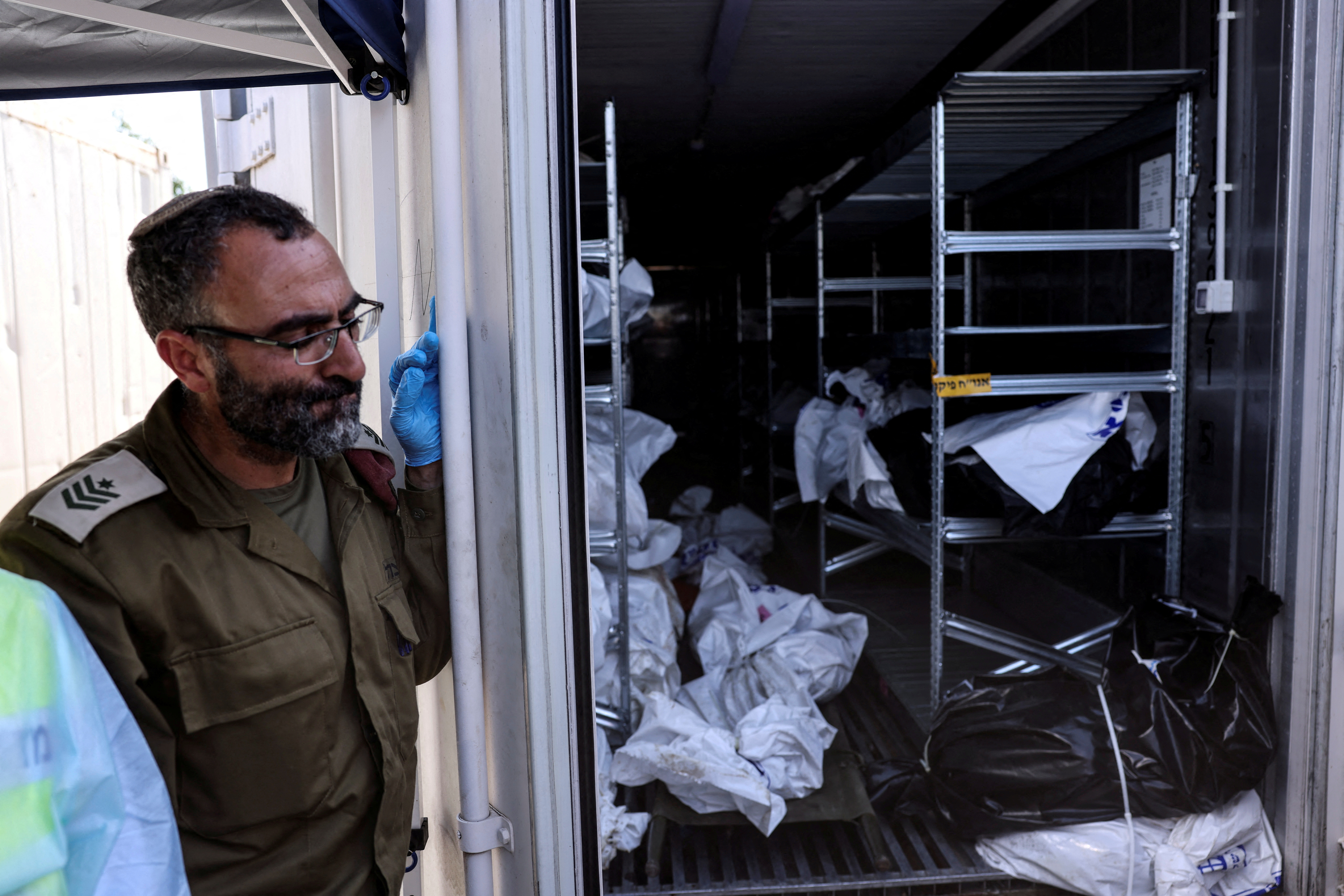 An Israeli military officer stands by a container in which bodies of the dead are stored before their relatives are called to identify them, following a mass infiltration by Hamas gunmen from the Gaza Strip, in Ramla, Israel, October 13, 2023. REUTERS