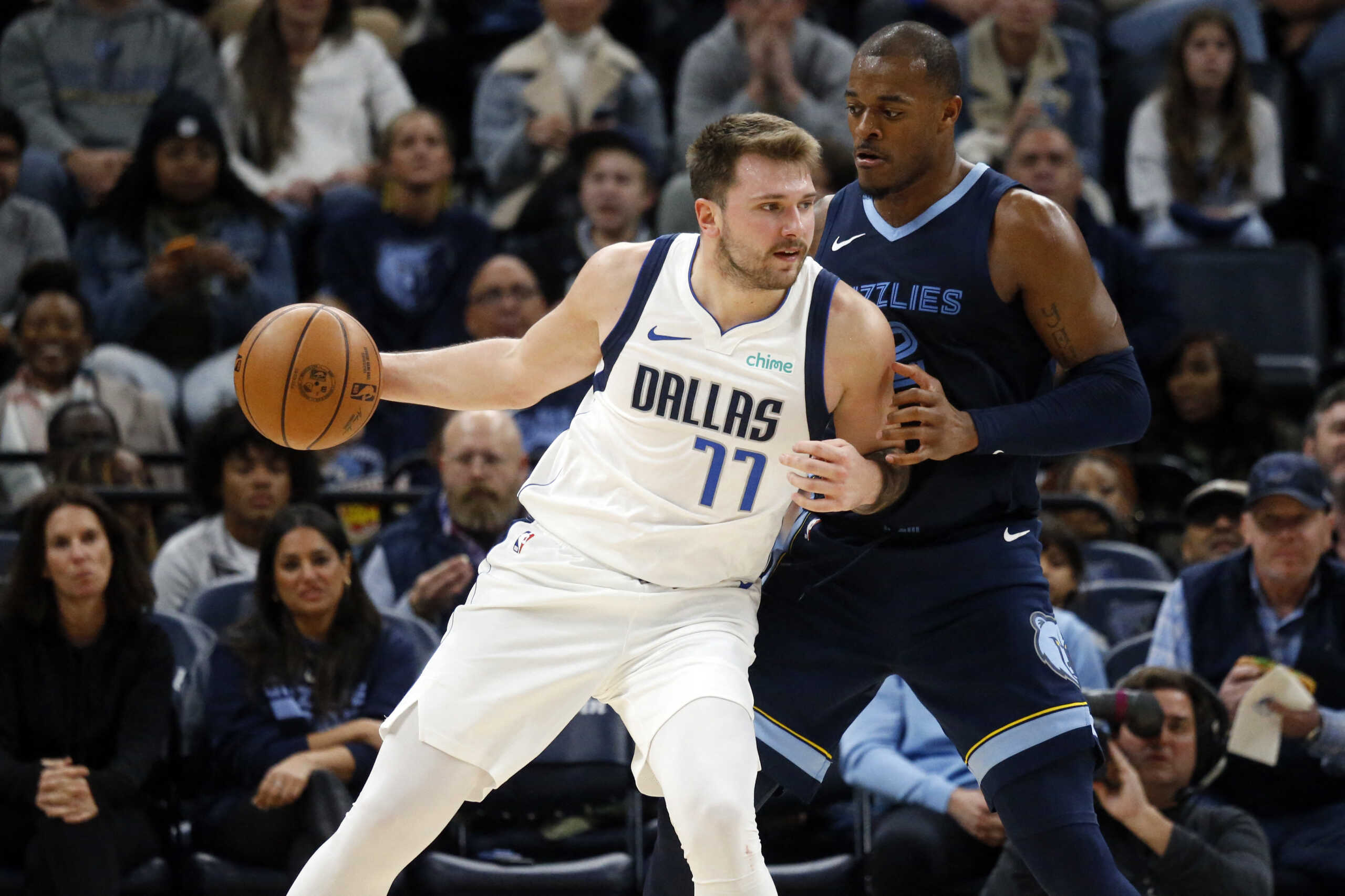 Oct 30, 2023; Memphis, Tennessee, USA; Dallas Mavericks guard Luka Doncic (77) handles the ball as Memphis Grizzlies forward Xavier Tillman (2) defends during the second half at FedExForum. Mandatory Credit: Petre Thomas-USA TODAY Sports