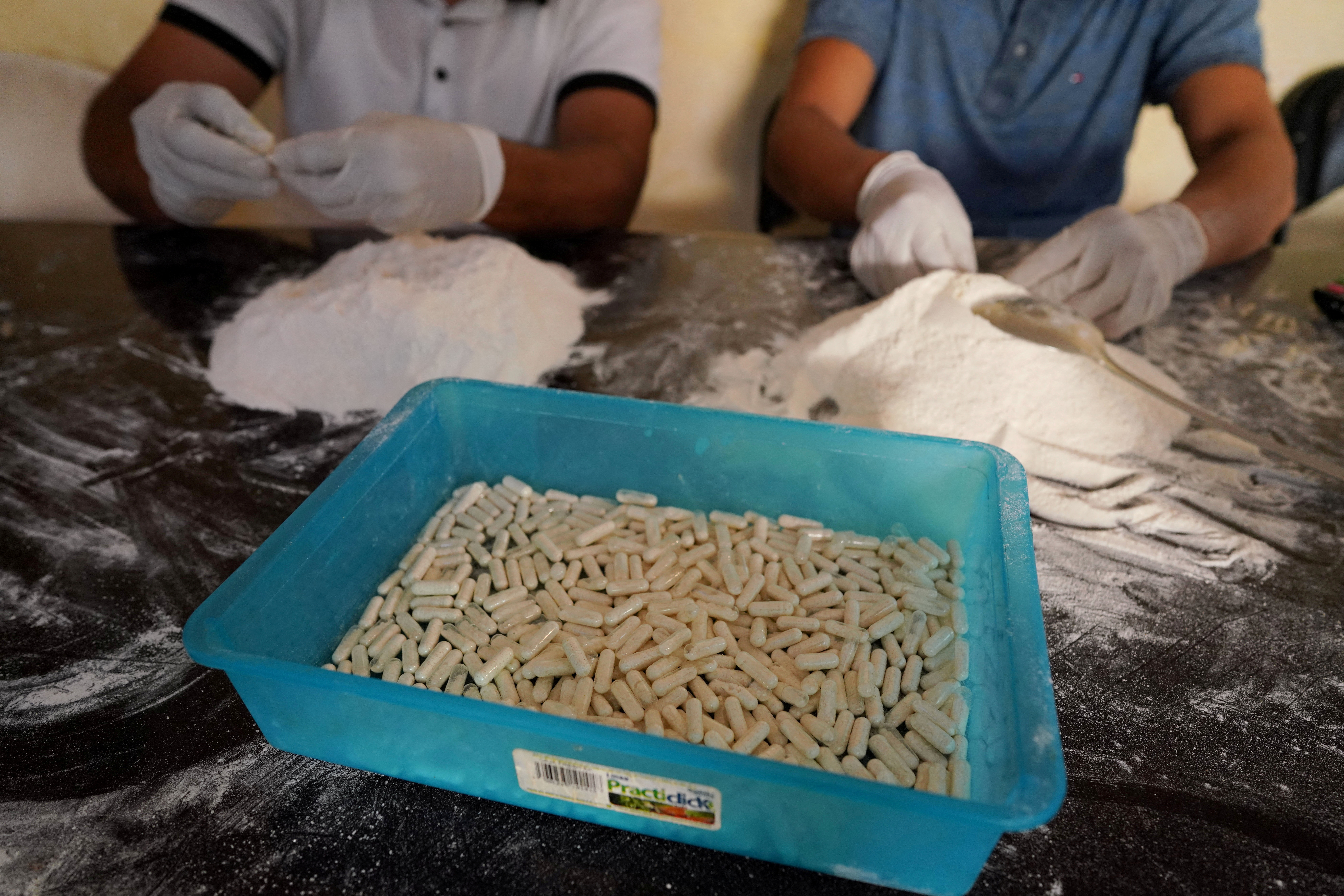 FILE PHOTO: Members of the Sinaloa Cartel prepare capsules with methamphetamine in a safe house in Culiacan, Mexico, April 4, 2022. REUTERS