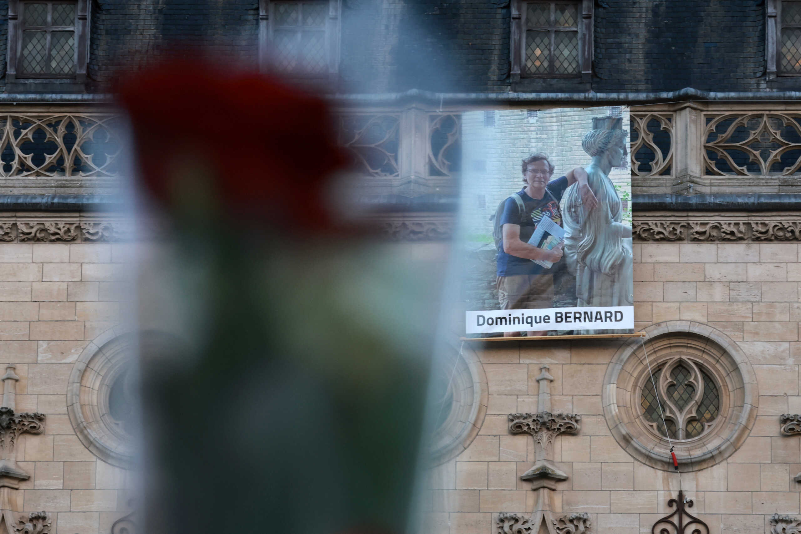 A portrait of French teacher Dominique Bernard, who was killed in a knife attack in a high school, hangs on the beffroi (belfry) of Arras city hall before the funeral ceremony at the Notre-Dame-et-Saint-Vaast Cathedral in Arras, northern France, October 19, 2023. REUTERS