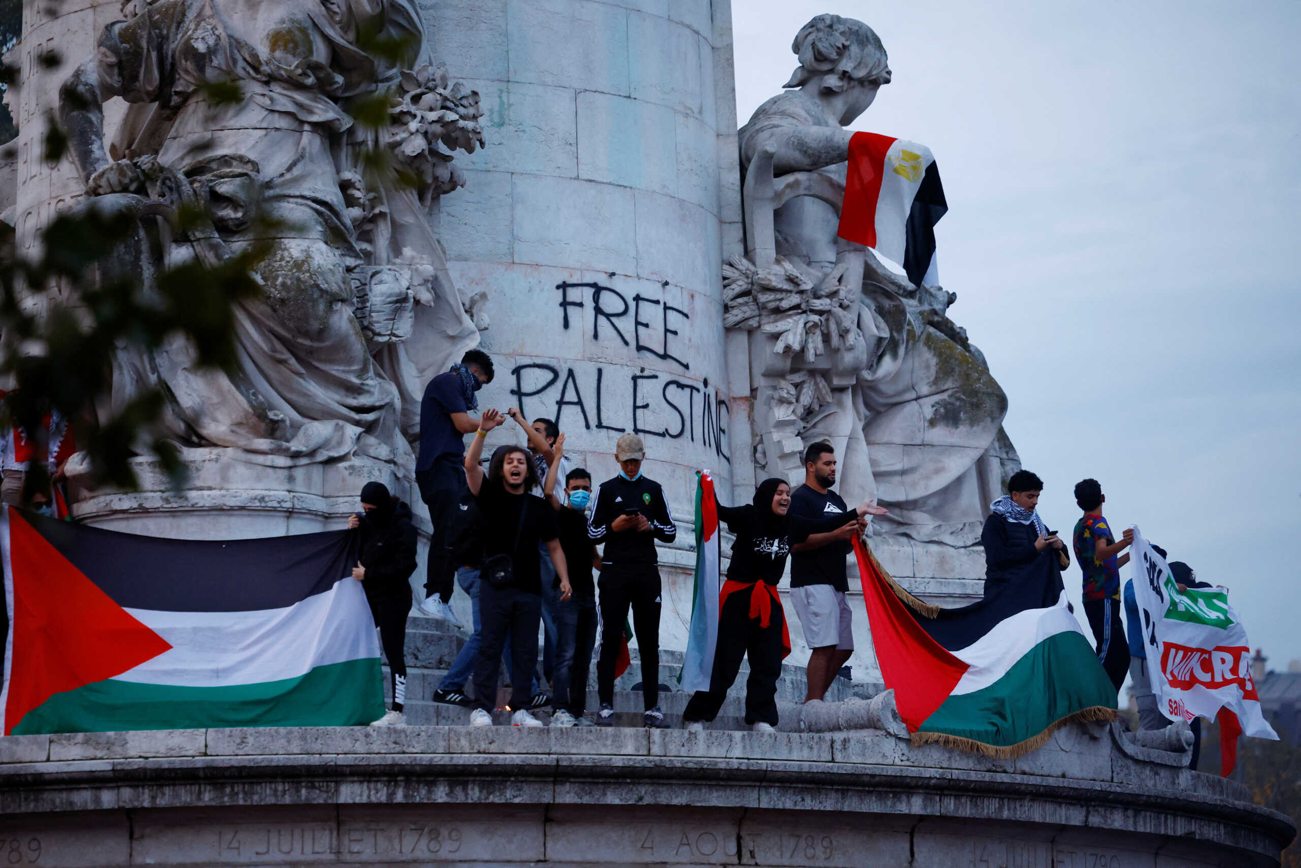 Protestors hold Palestinian flags during an unauthorized demonstration in support of Palestinians, as part of the ongoing conflict between Israel and the Palestinian Islamist group Hamas, at Place de la Republique in Paris as French Interior Minister Gerald Darmanin ordered the systematic banning of pro-Palestinian demonstrations and the arrest of participants within France, October 12, 2023. REUTERS