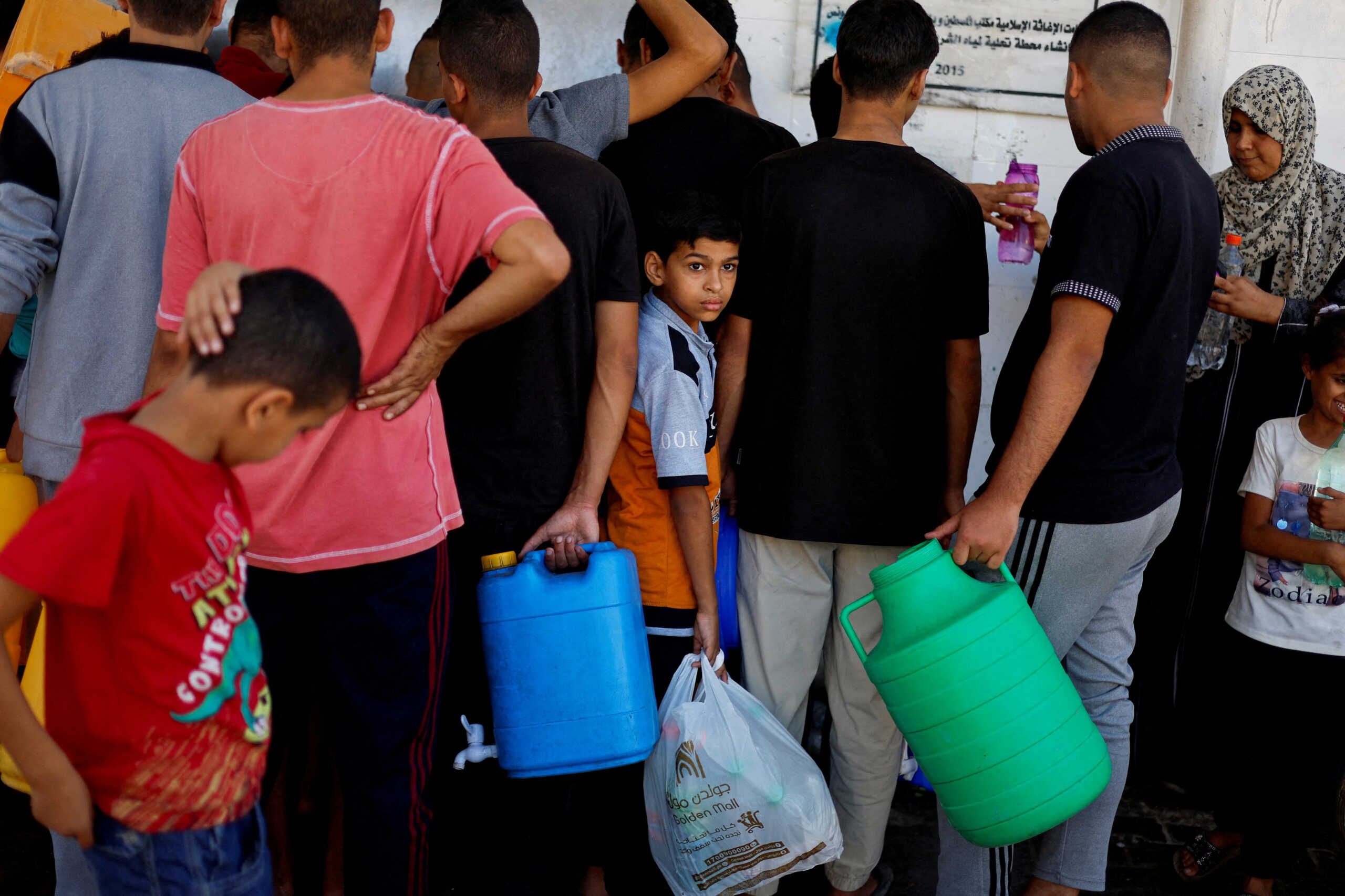 Palestinians gather to collect water, amid shortages of drinking water, as the Israeli-Palestinian conflict continues, in Khan Younis in the southern Gaza Strip October 15, 2023. REUTERS