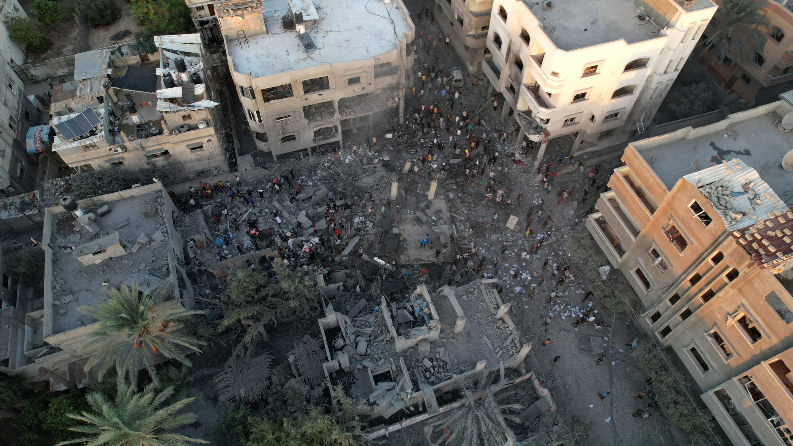 People gather at the site of Israeli strikes on houses in the central Gaza Strip, October 18, 2023. REUTERS