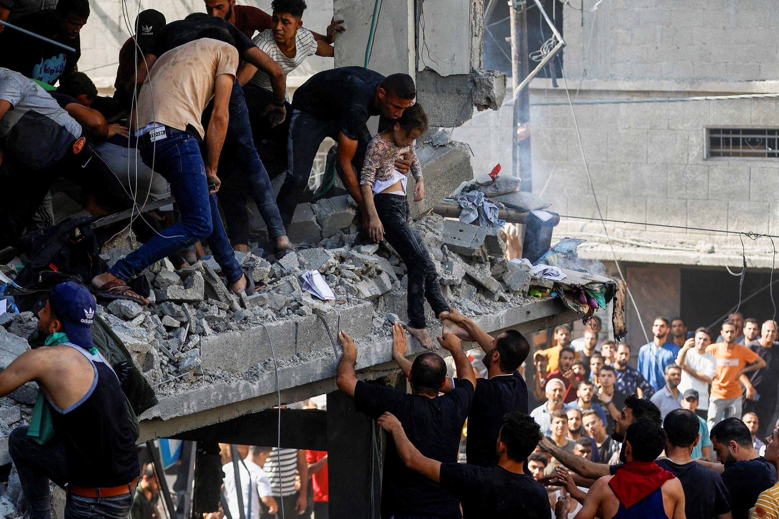 Palestinians carry a child casualty at the site of an Israeli strike on a house, in Khan Younis, in the southern Gaza Strip, October 24, 2023. REUTERS