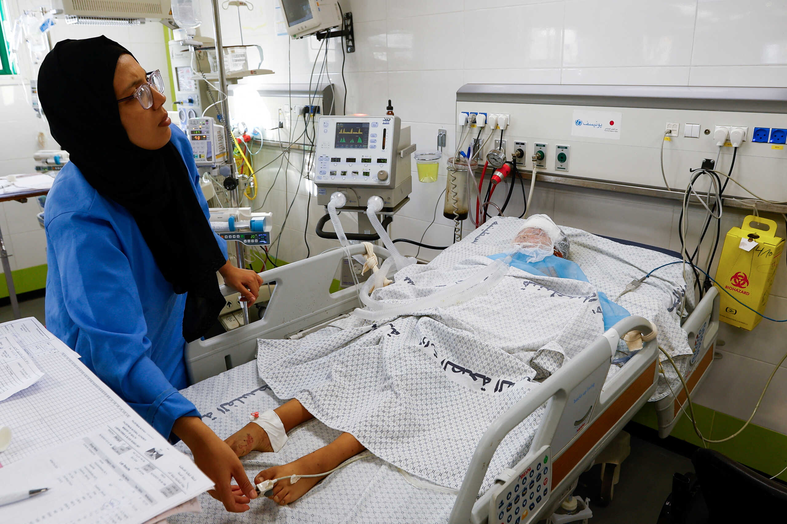 A medical worker assists a Palestinian boy, who was wounded in Israeli strikes, at the Intensive Care Unit (ICU) of Nasser hospital, as doctors say they are only able to accept critical cases that are in need of surgery, while the unit is filled up with victims of the ongoing conflict with Israel, in Khan Younis, in the southern Gaza Strip, October 26, 2023. REUTERS