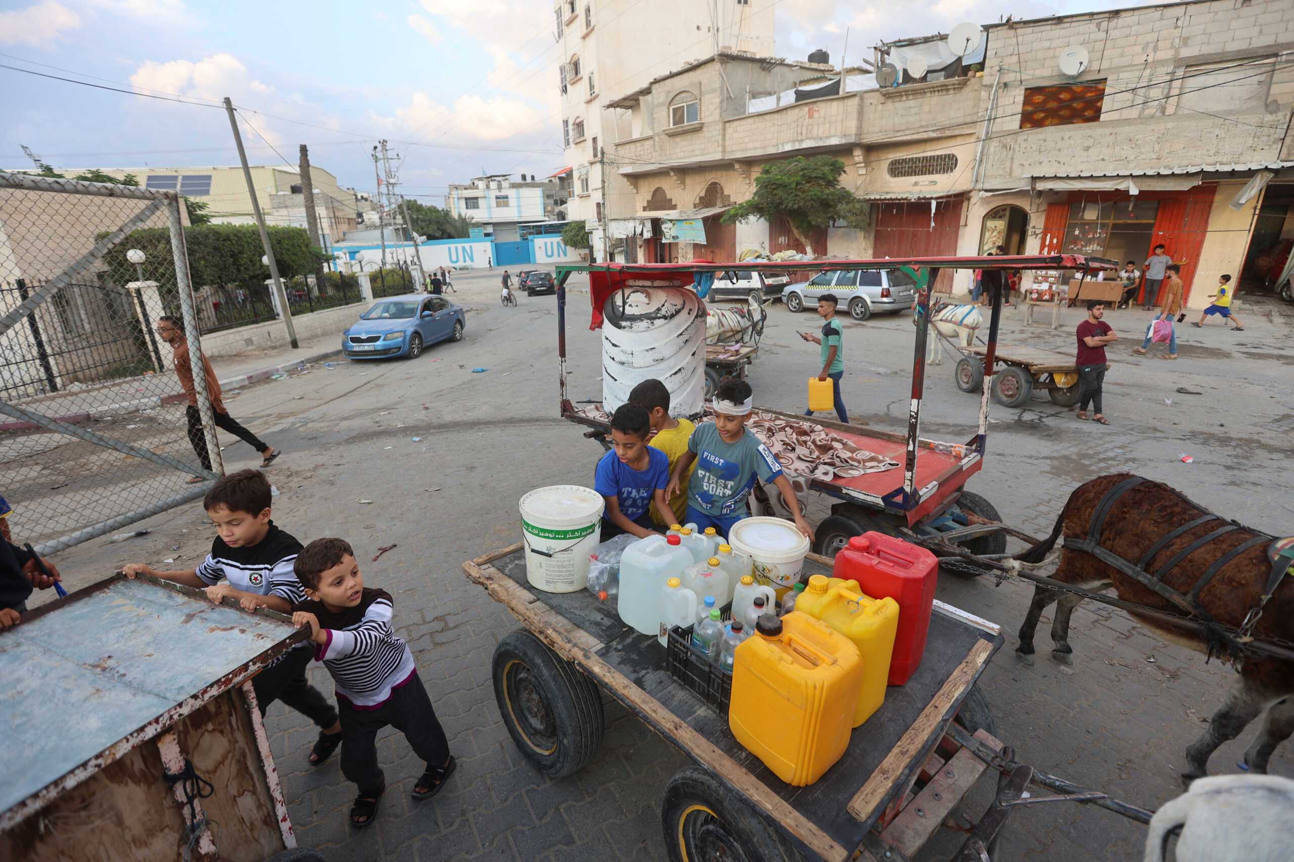 Palestinian children collect water, amid the ongoing Israeli-Palestinian conflict in Khan Younis in the southern Gaza Strip, October 14, 2023. REUTERS