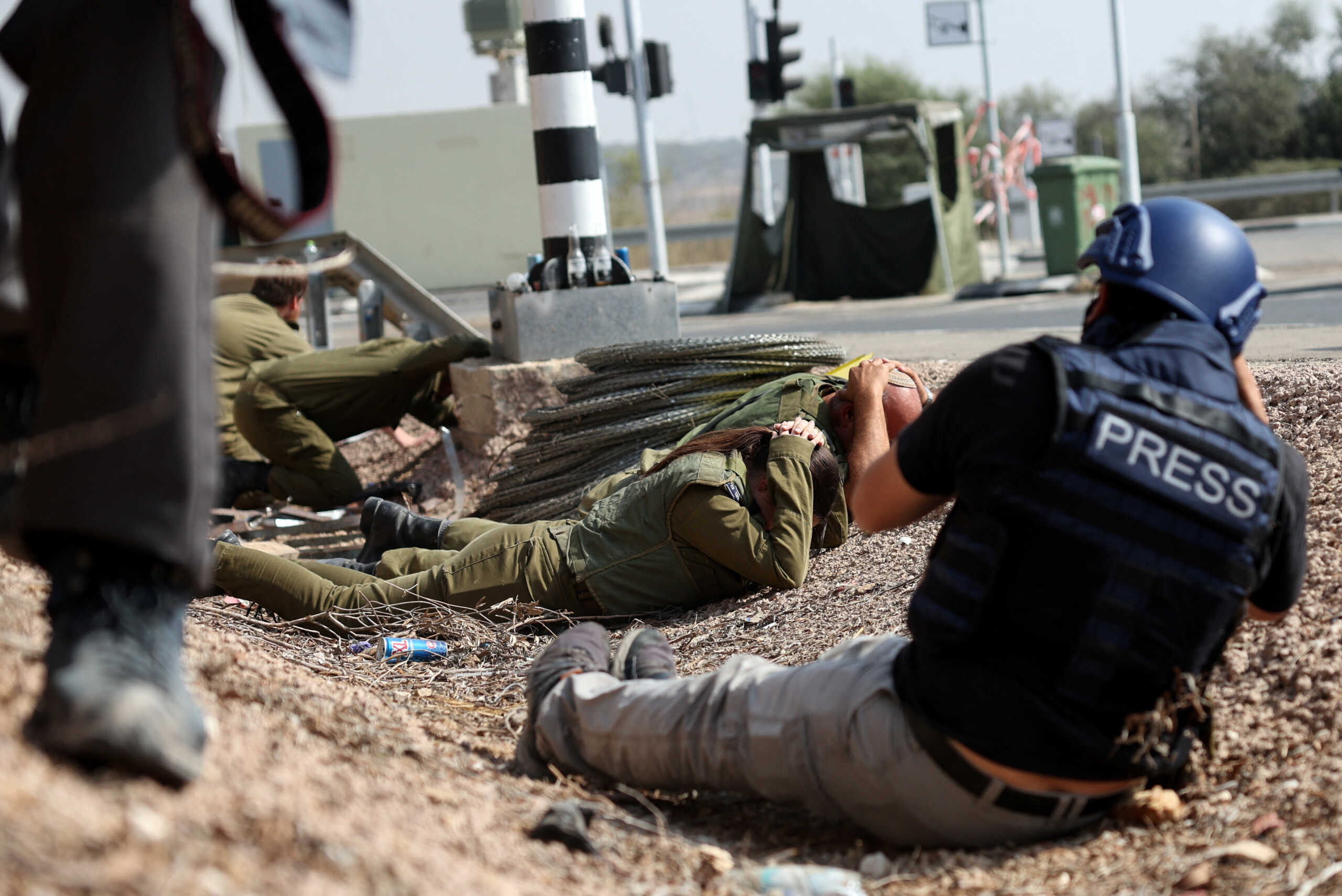 Members of the press photograph Israeli soldiers as they take cover as sirens for incoming rocket launched from the Gaza Strip sound near Israel's border with Gaza in southern Israel, October 24, 2023. REUTERS