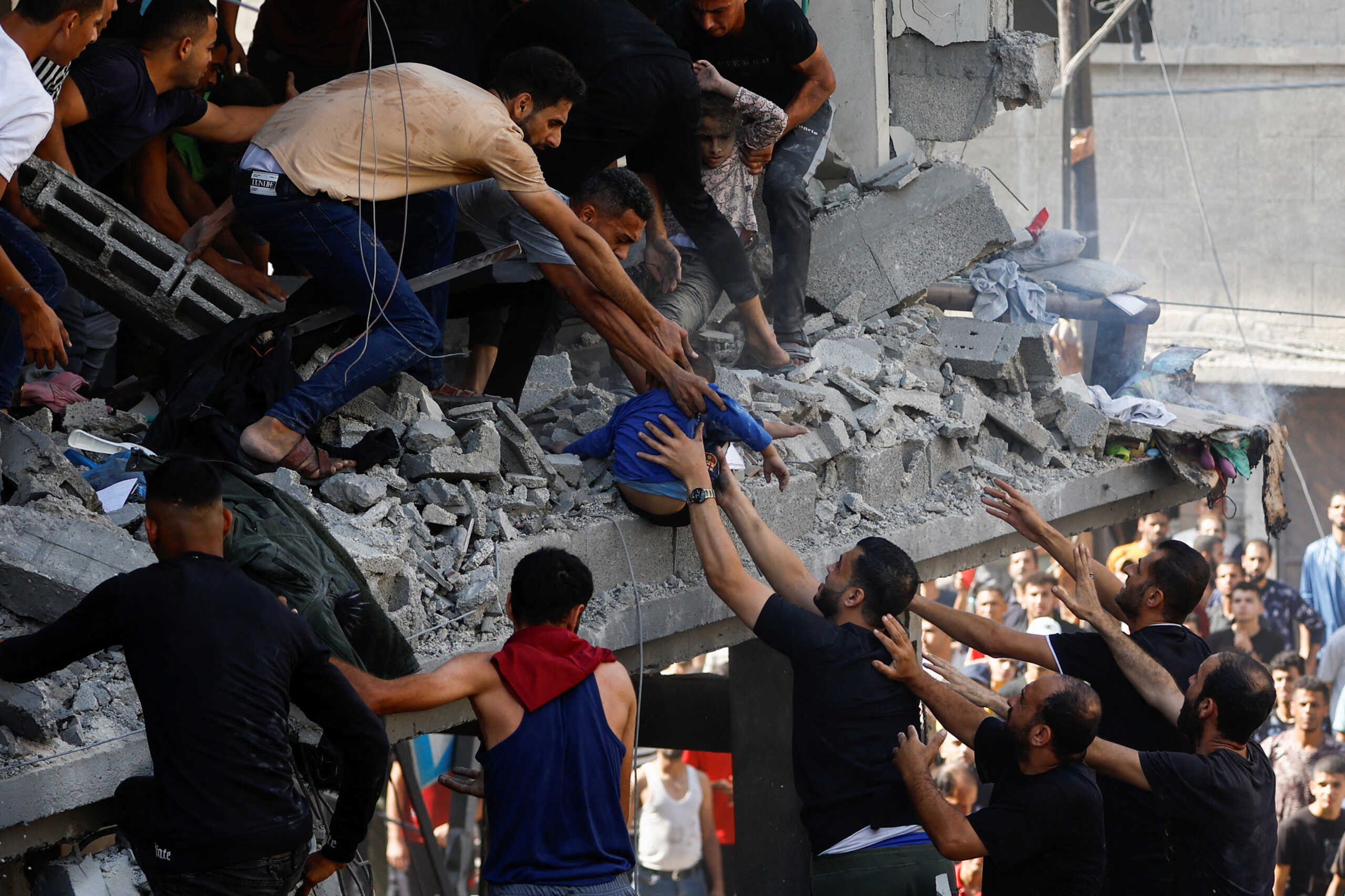 Palestinians carry a child casualty at the site of an Israeli strike on a house, in Khan Younis, in the southern Gaza Strip, October 24, 2023. REUTERS