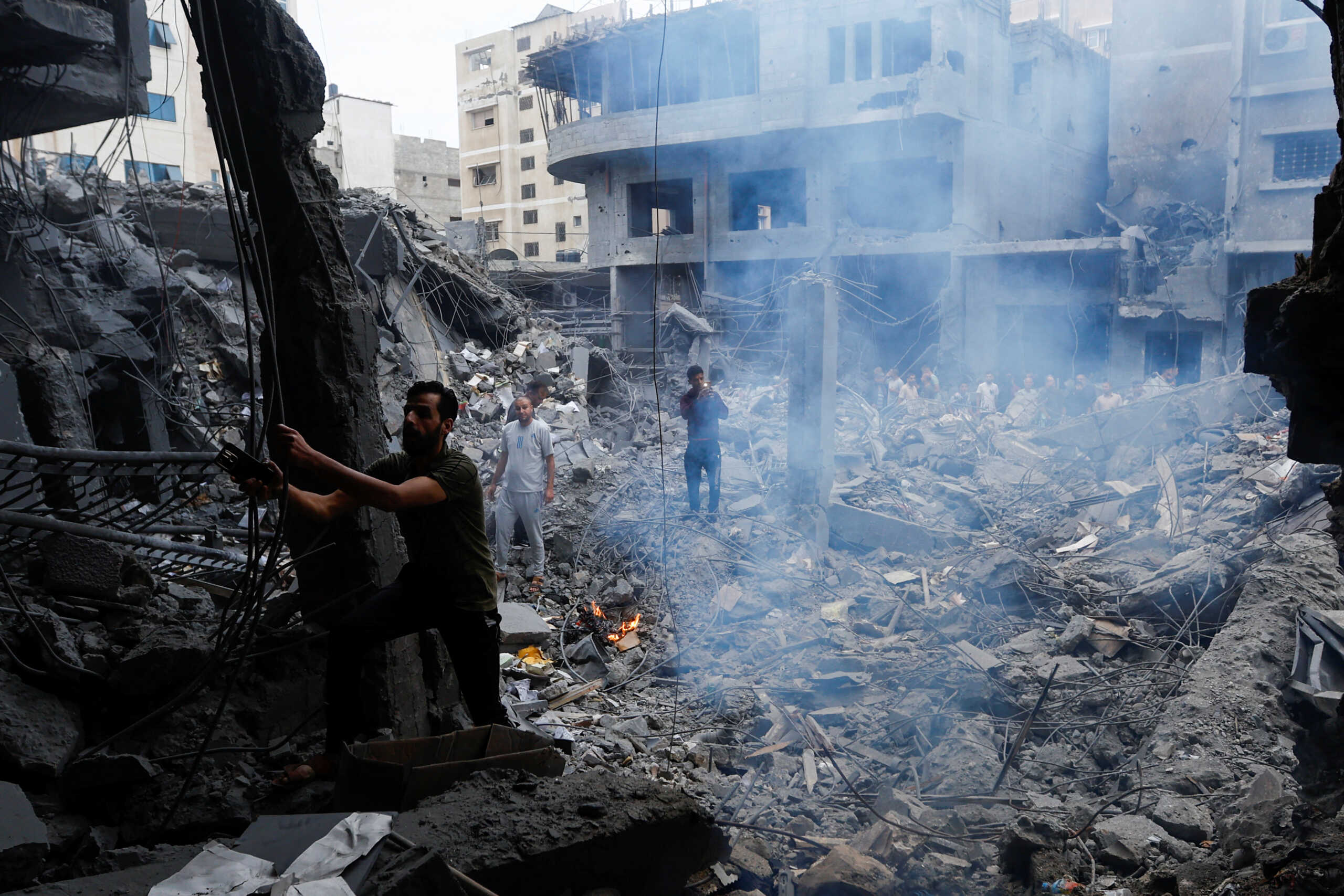 Palestinians inspect a residential building destroyed in the aftermath of Israeli strikes, in Khan Younis, southern Gaza Strip October 10, 2023. REUTERS