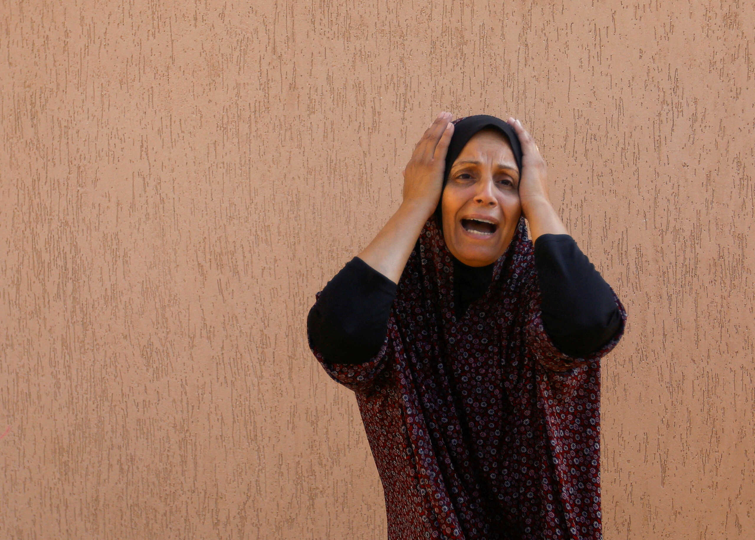A Palestinian woman reacts in the aftermath of Israeli strikes, in Khan Younis in the southern Gaza Strip, October 14, 2023.  REUTERS