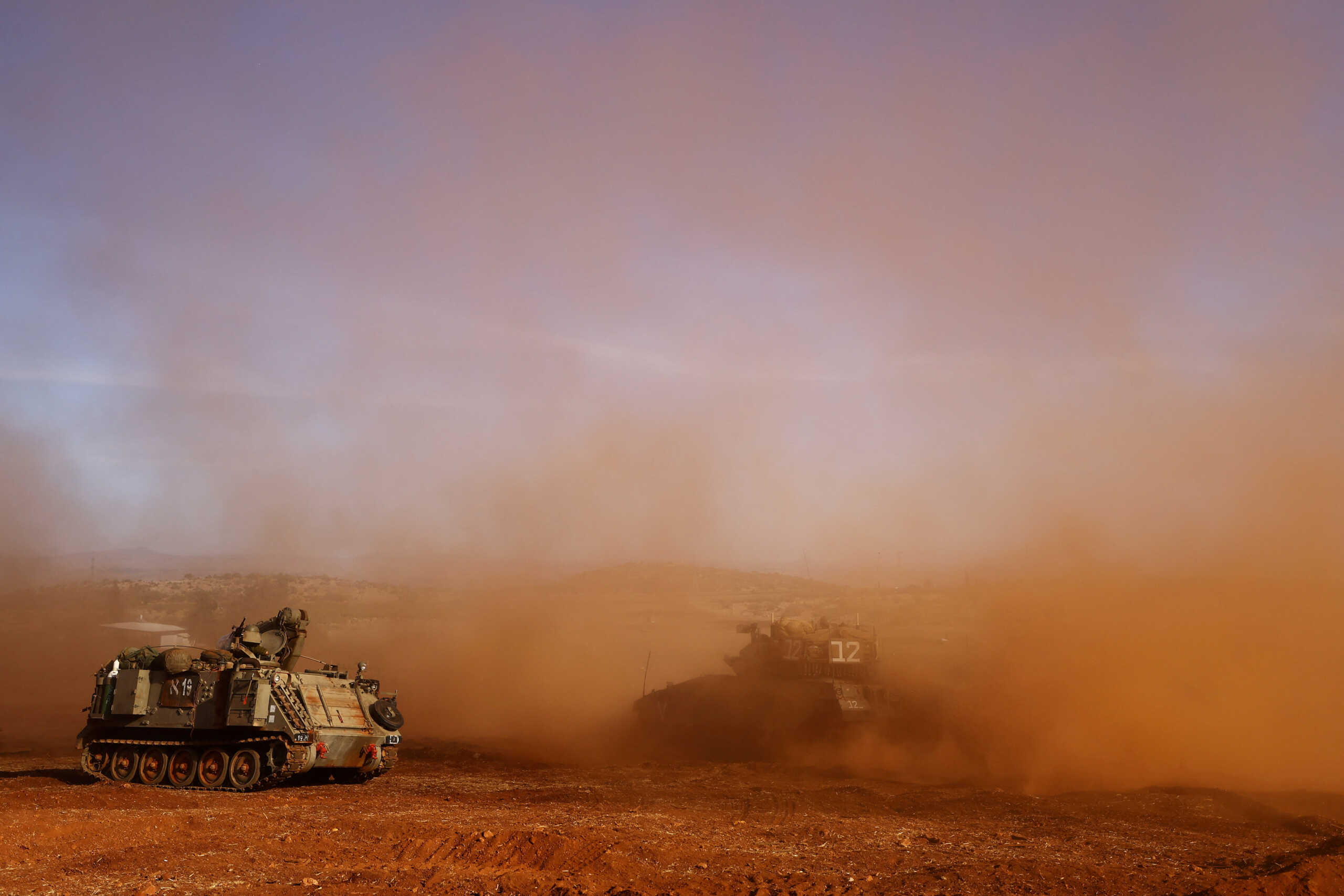 An Israeli armoured personnel carrier (APC) and an Israeli tank participate in a drill near Israel's border with Lebanon in northern Israel, October 26, 2023. REUTERS