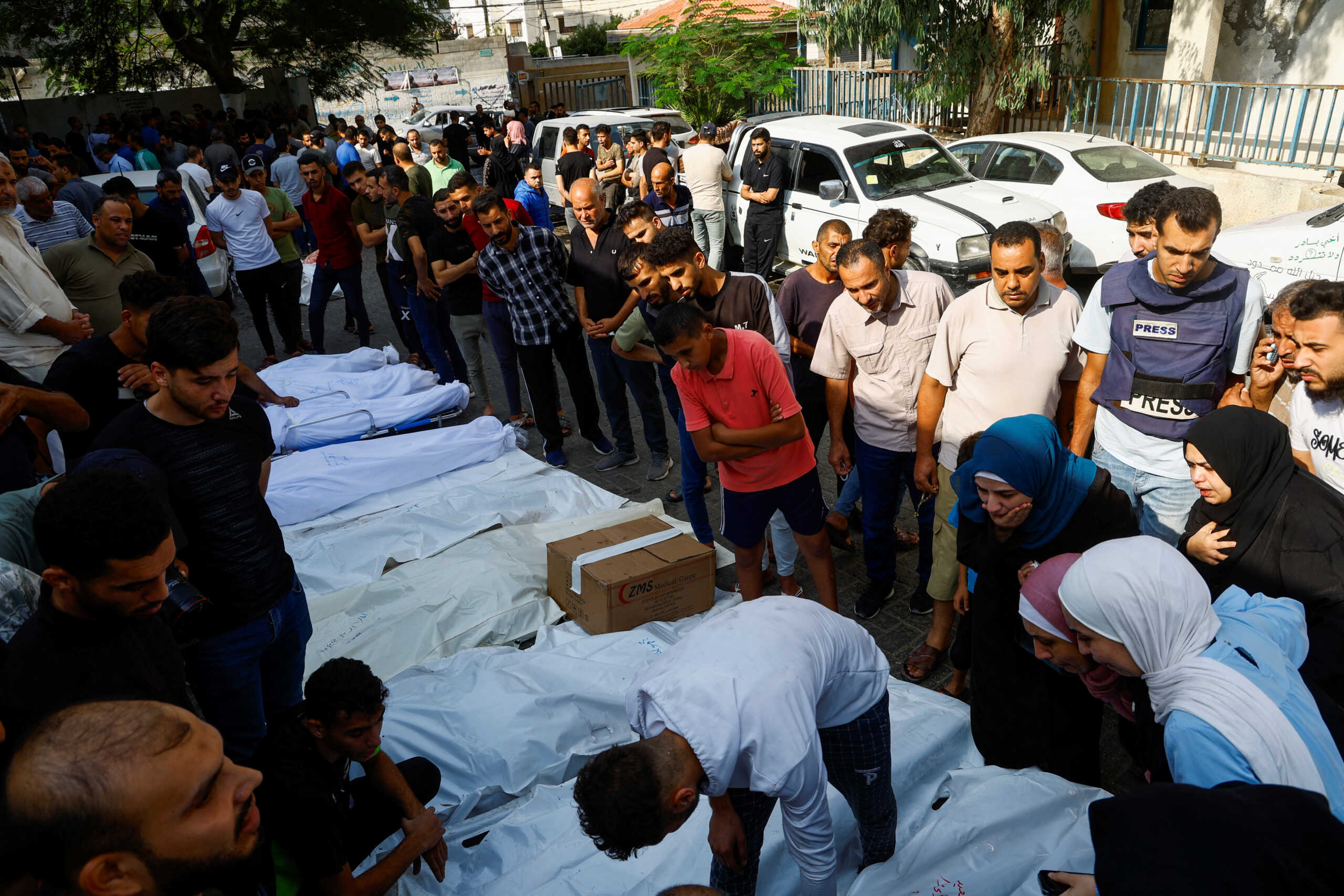 Relatives react next to the bodies of Palestinians killed in Israeli strikes, at a hospital in Gaza City, October 11, 2023. REUTERS
