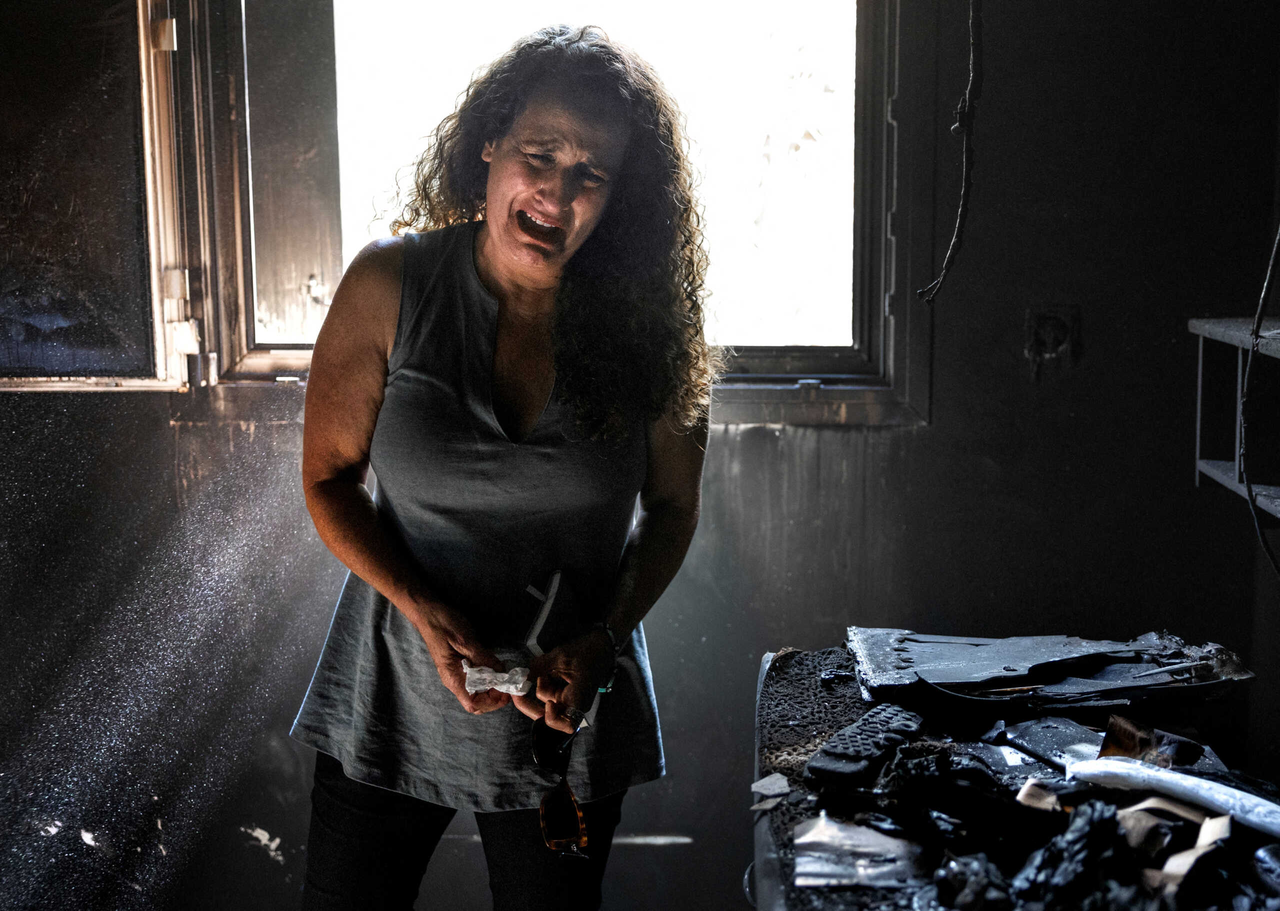 Hadas Kalderon, whose three members of the family, two children Erez and Sahar, and their father, Ofir have been kidnapped, while Hadas' mother and niece were killed, cries in the burned-out remains of her mother's home, following a deadly attack by Hamas gunmen from the Gaza Strip on Kibbutz Nir Oz, in southern Israel, October 30, 2023. REUTERS