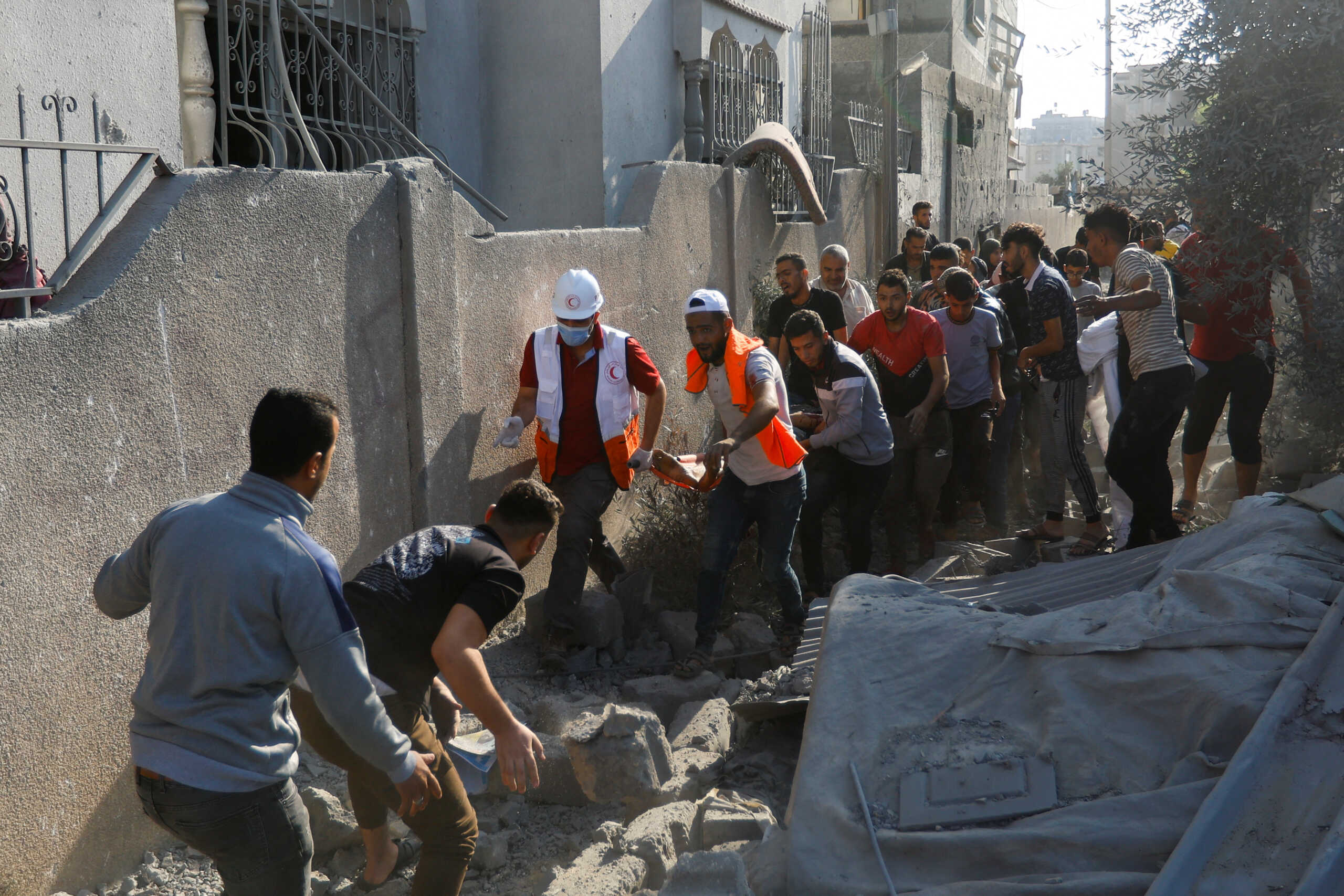 SENSITIVE MATERIAL. THIS IMAGE MAY OFFEND OR DISTURB    Palestinians carry a casualty in the aftermath of Israeli strikes, in Khan Younis in the southern Gaza Strip, October 14, 2023.  REUTERS