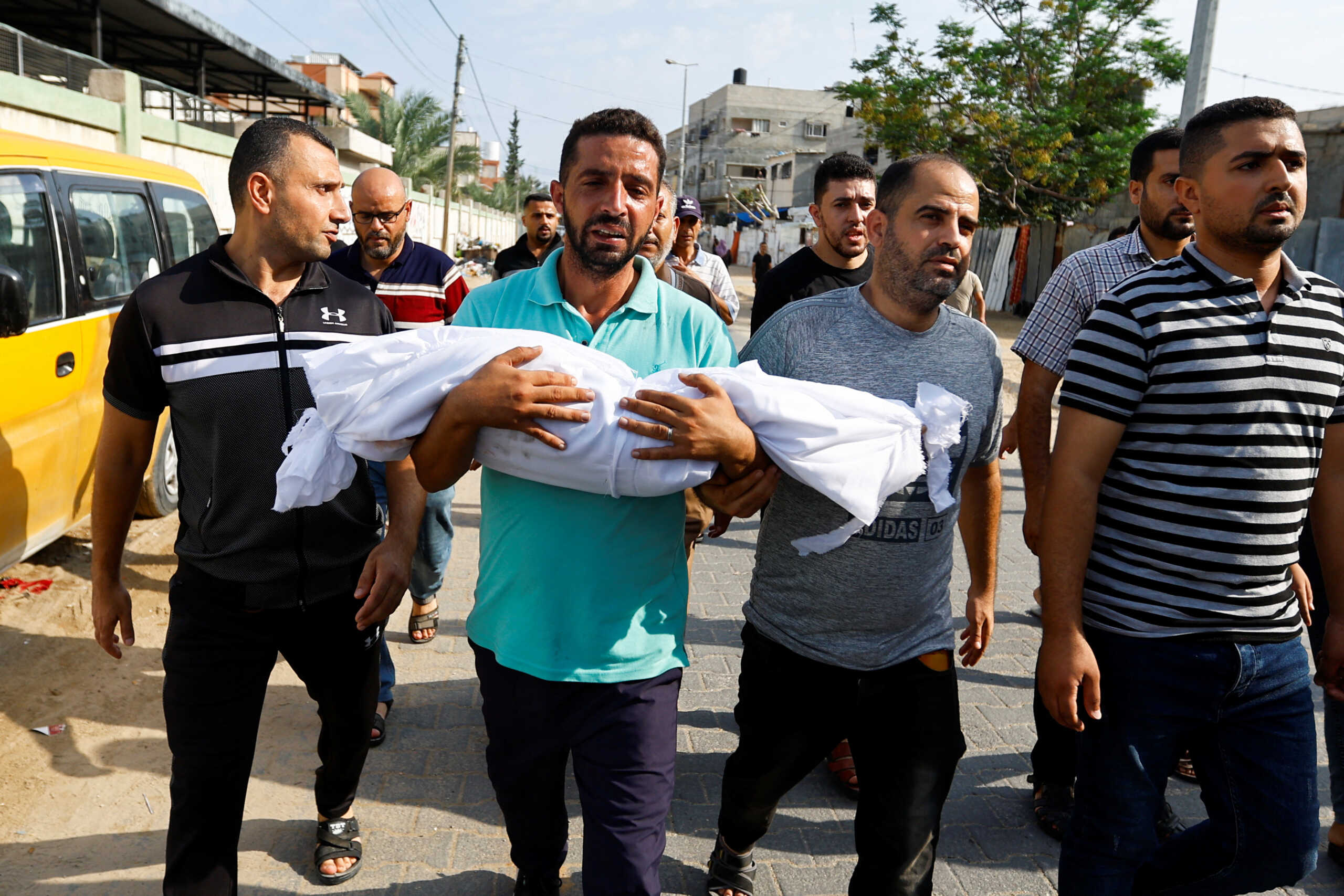 A mourner carries the body of a Palestinian killed in the Israeli strikes, in Khan Younis, southern Gaza Strip October 10, 2023. REUTERS