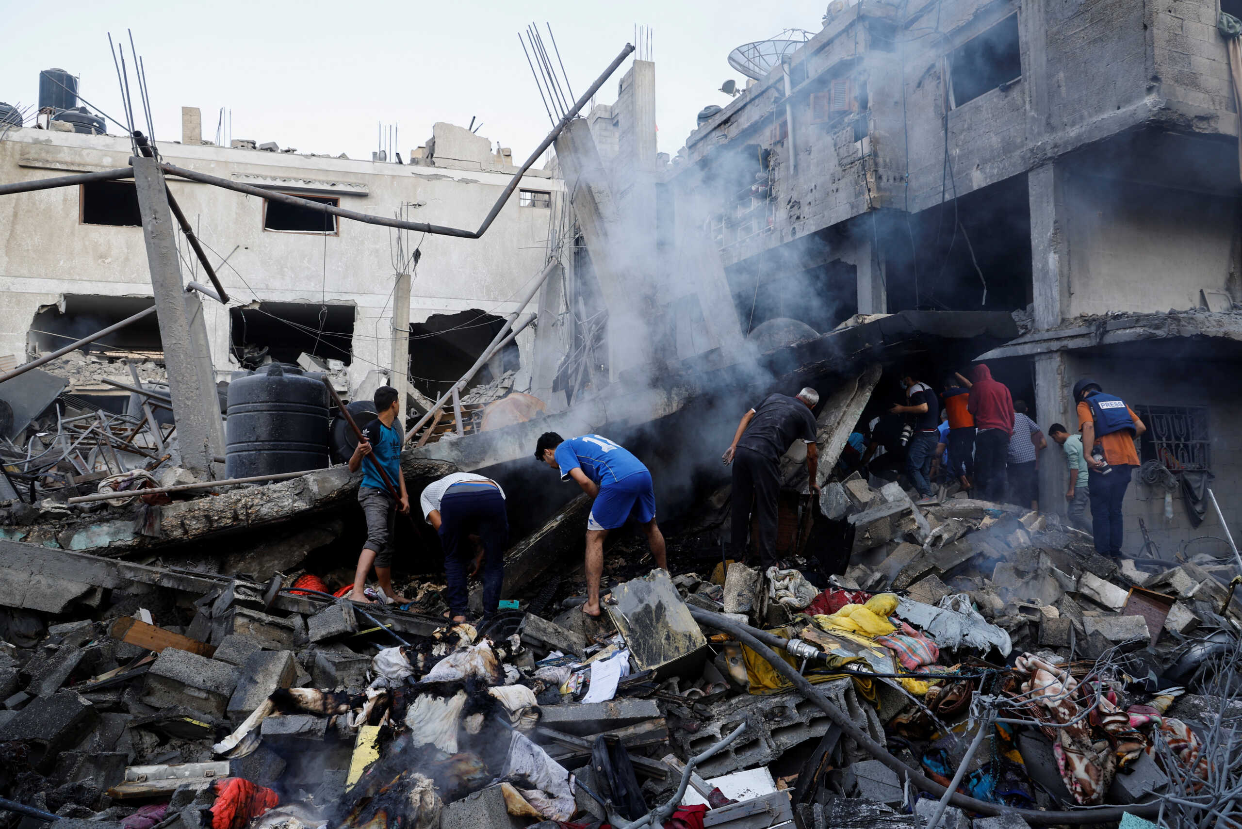 Palestinians search for casualties under the rubble in the aftermath of Israeli strikes, amid the ongoing conflict between Israel and the Palestinian Islamist group Hamas, in Khan Younis in the southern Gaza Strip, October 14, 2023. REUTERS