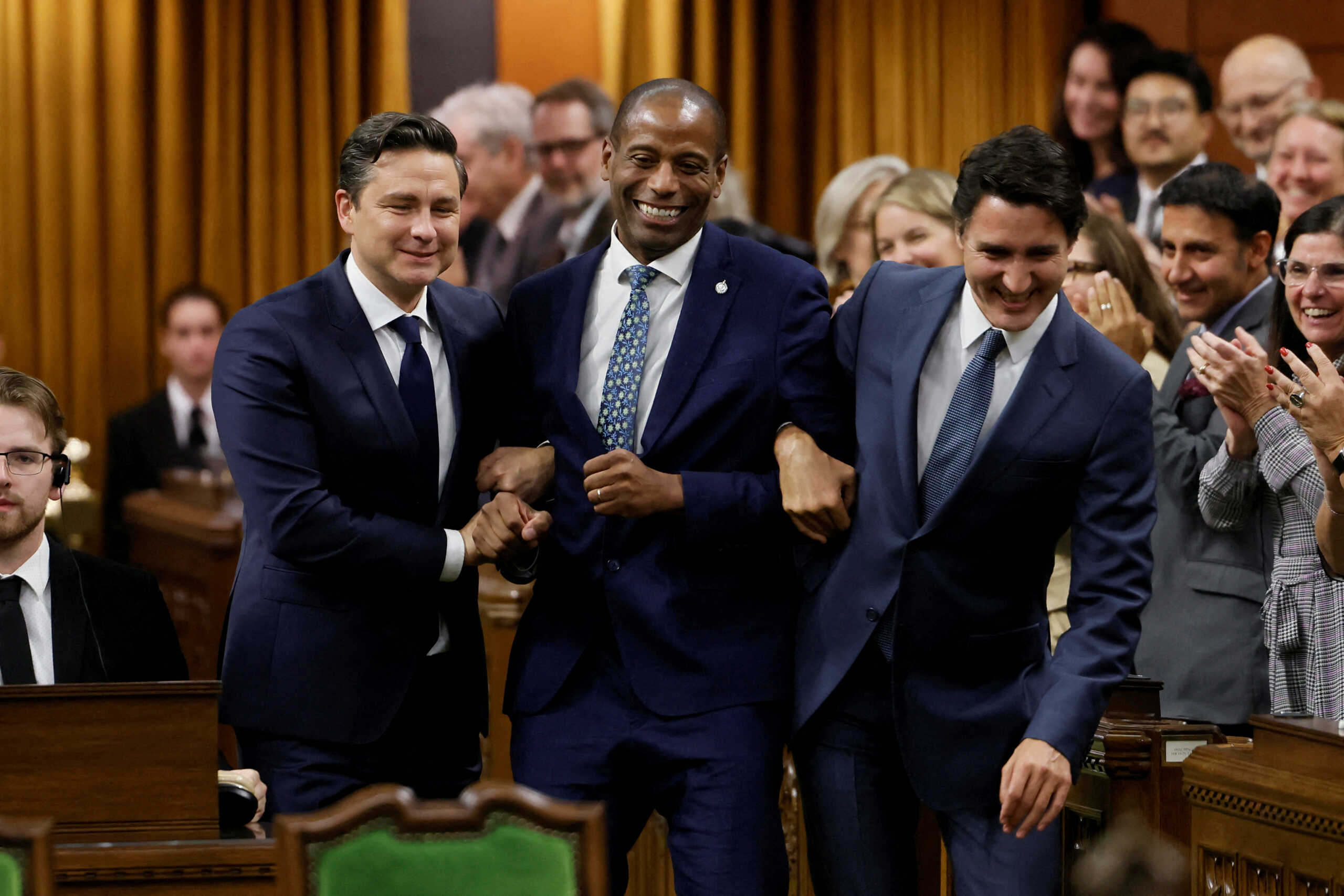 Newly elected Speaker Greg Fergus pretends to resist while being walked through the House of Commons by Canada's Prime Minister Justin Trudeau and Conservative Party of Canada leader Pierre Poilievre on Parliament Hill in Ottawa, Ontario, Canada October 3, 2023. REUTERS