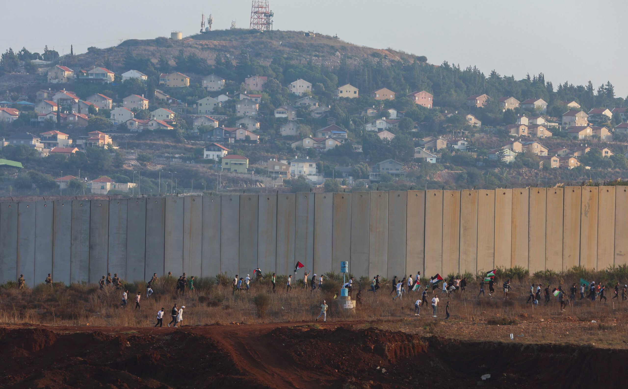 People hold Palestinian flags during a rally to express solidarity with Palestinians, in Kfar Kila village near the border with Israel, southern Lebanon, October 8, 2023. REUTERS