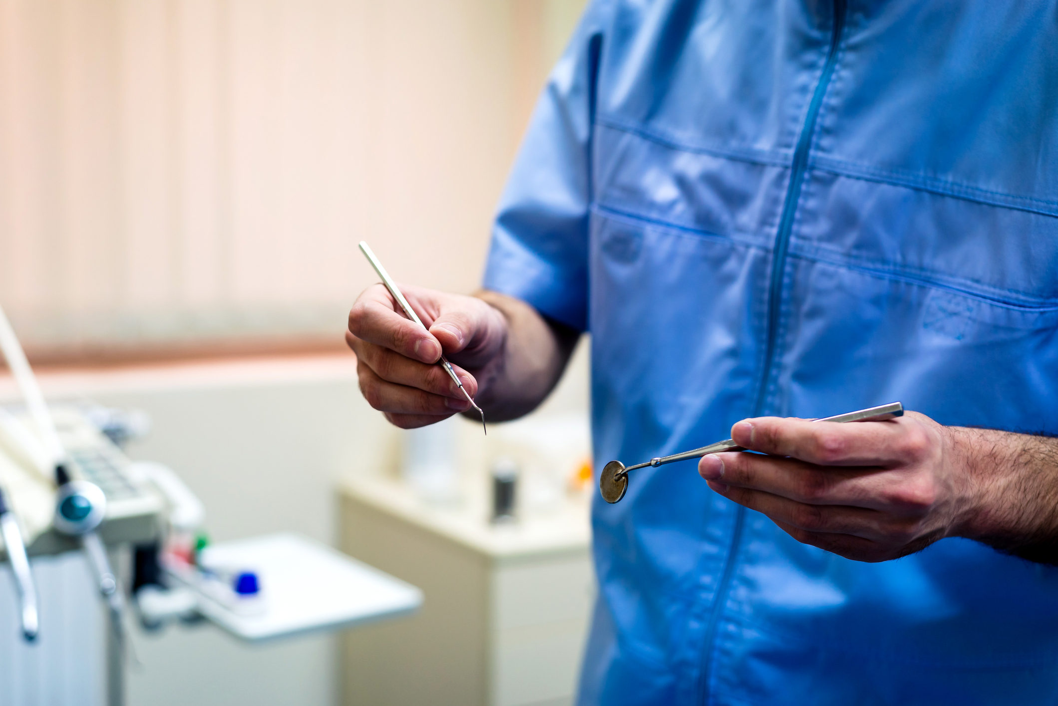 Dentist holding a dental mirror and probe closeup