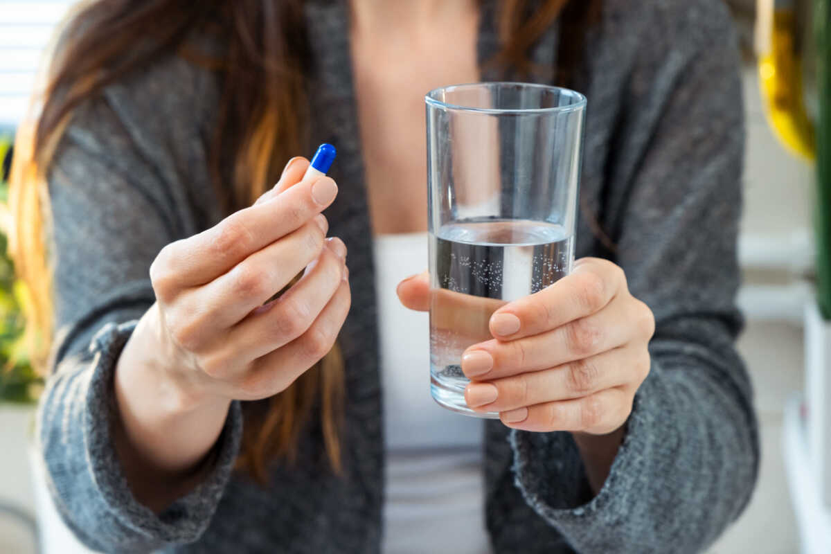 Close-up of woman hands holding medicine pills