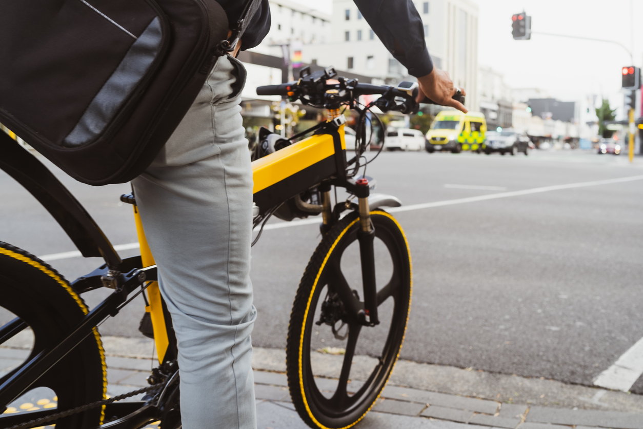 The portrait of a businessman using electric bicycle to go to work in cityscape.