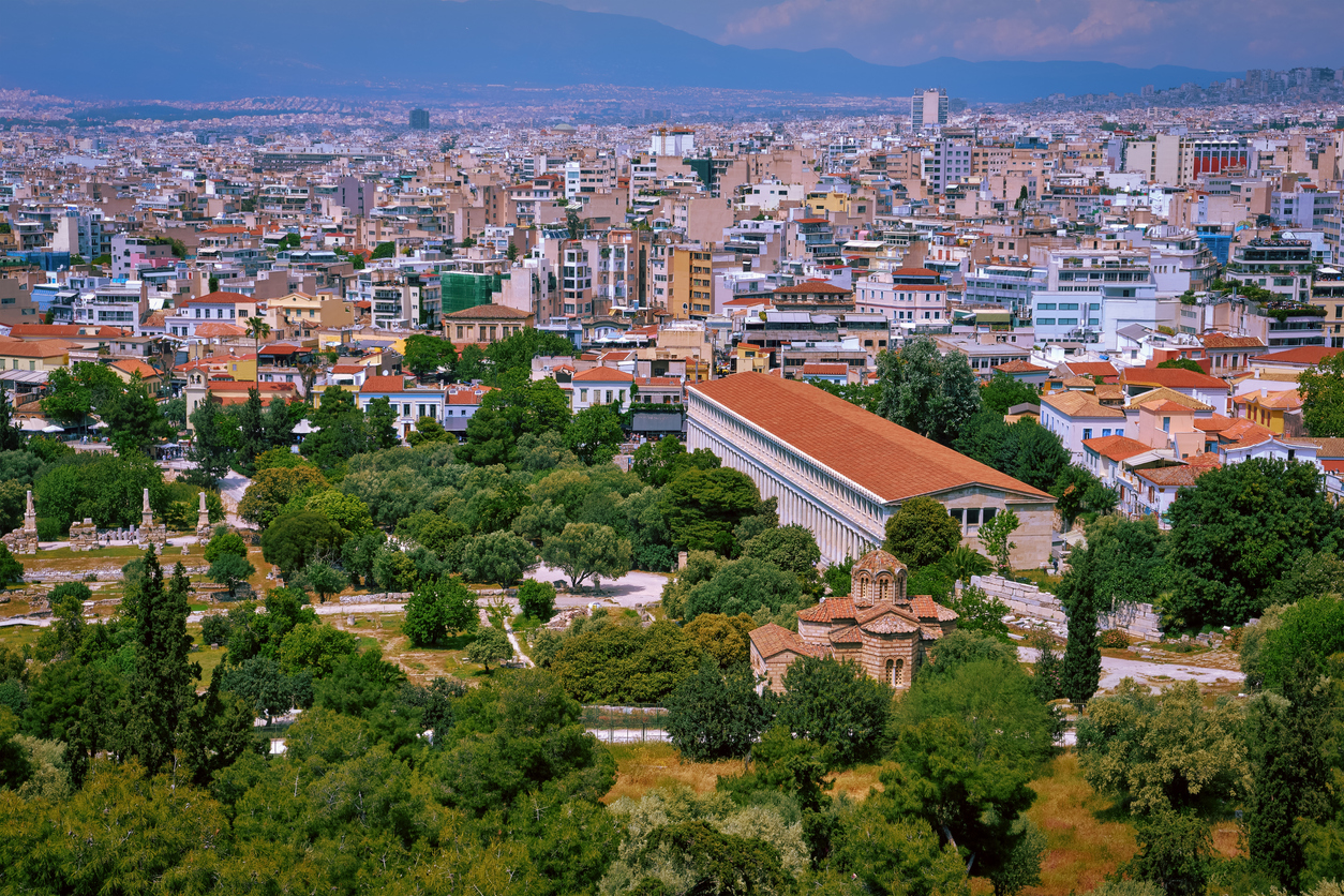 Aerial city view of Athens, capital of Greece across ancient Agora of Athens. Stoa of Attalos, Odeon of Agrippa and Church of Holy Apostles or Solakis in foreground at summer daylight.