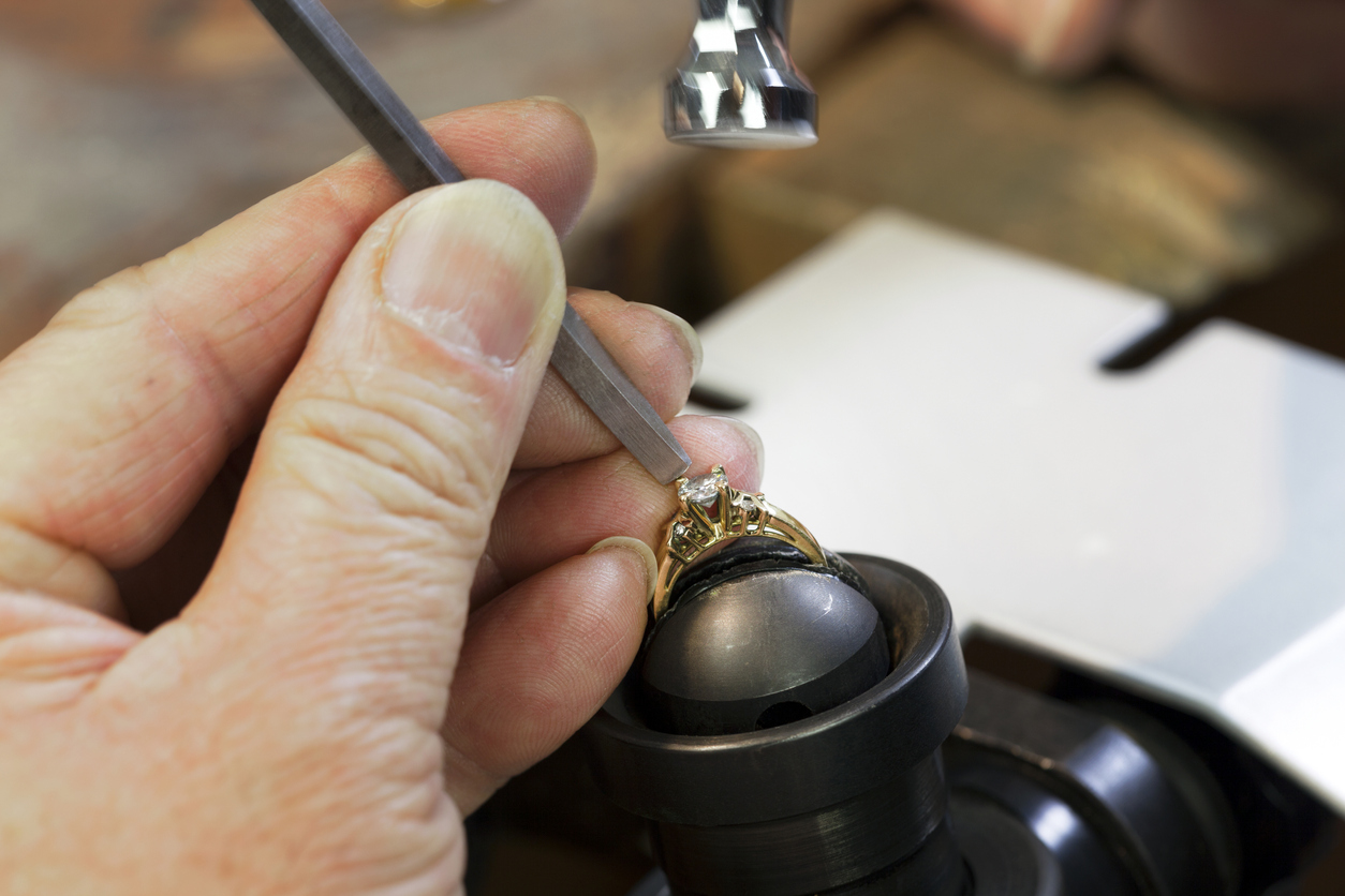 A Jeweller is Repairing a Diamond Ring & setting a Diamond on the Ring with Motion Blur on the Hammer.