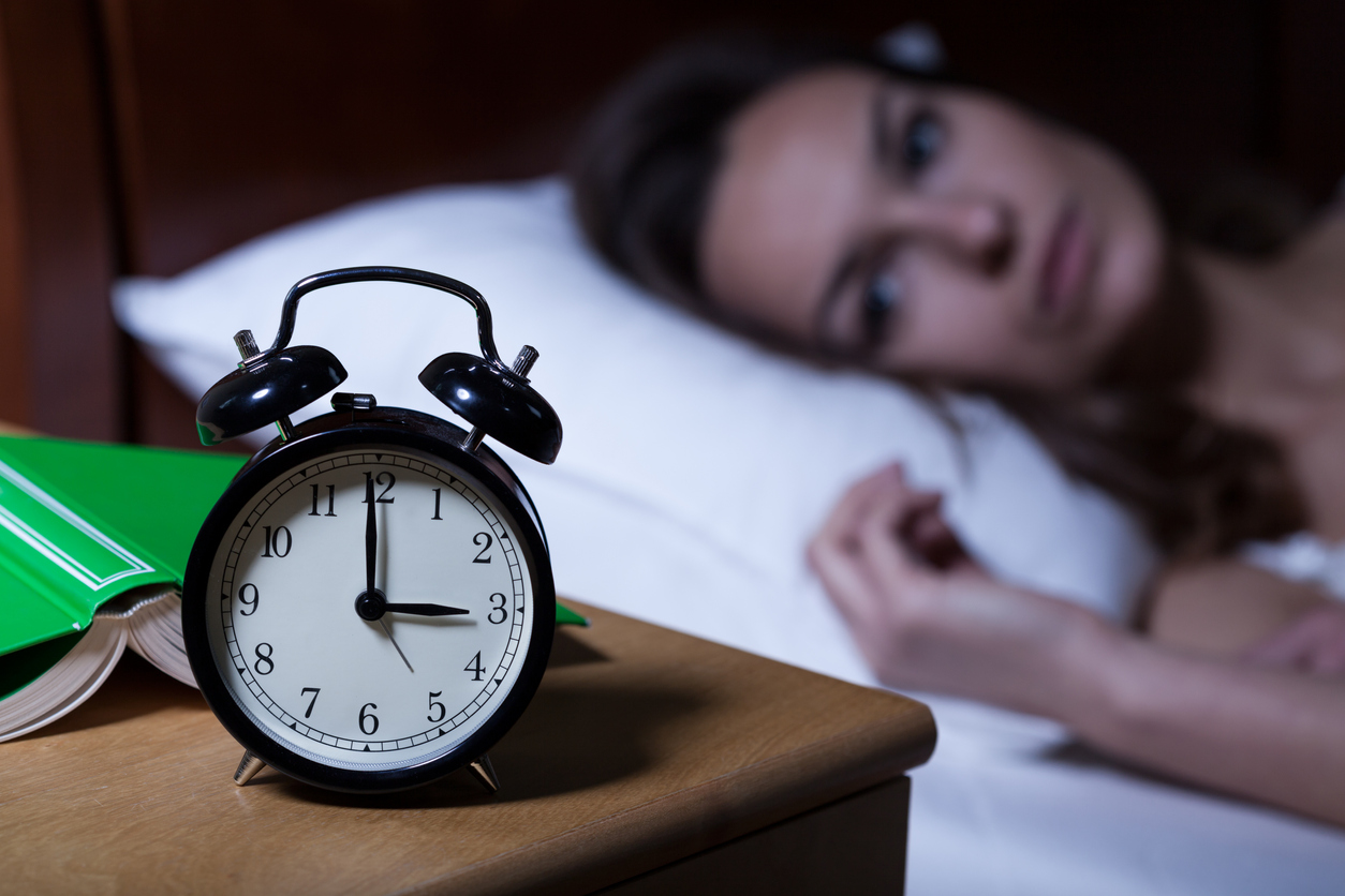Alarm clock on night table showing 3 a.m.