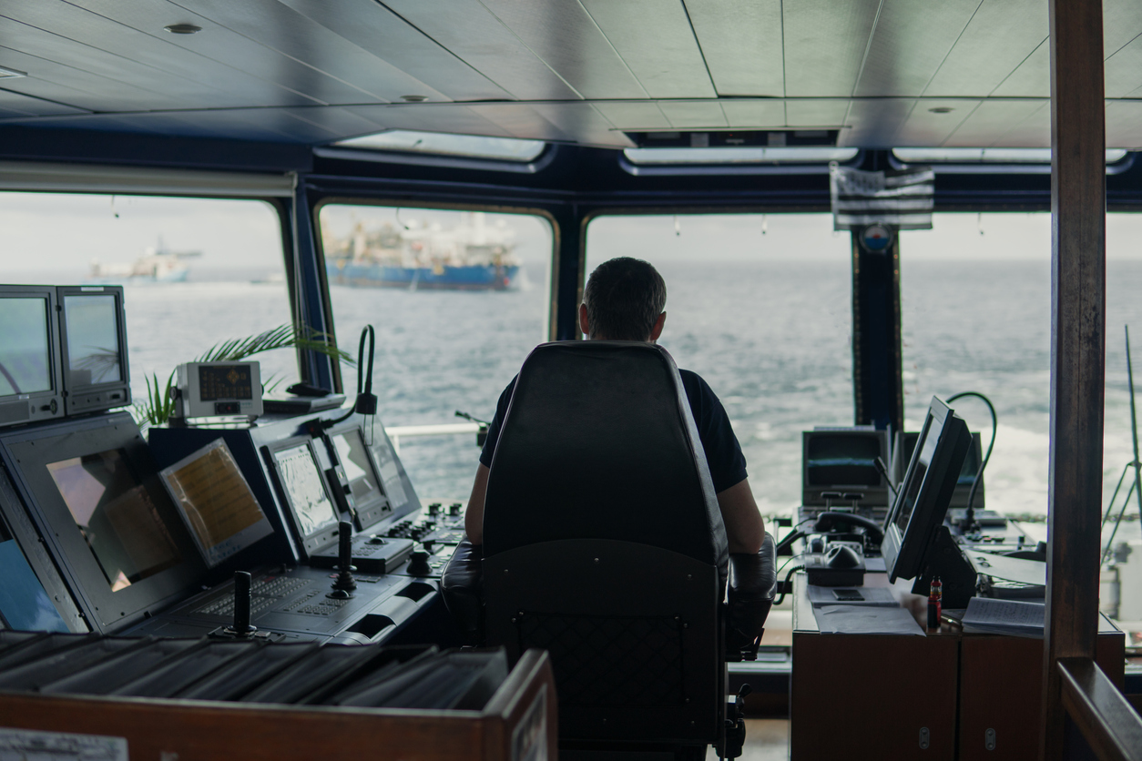 Deck navigation officer on the navigation bridge. He looks to sea. Watchkeeping, collision prevention at sea. COLREG
