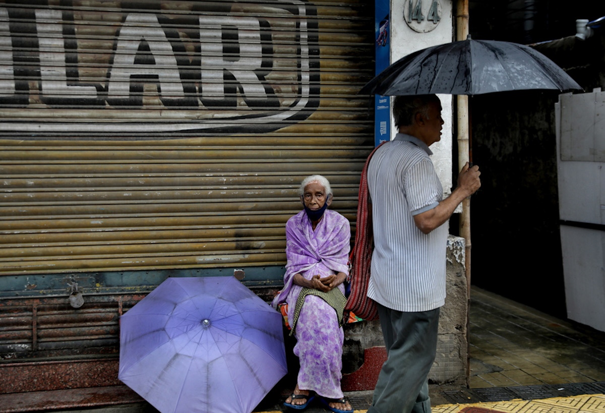 epa10898753 An Indian commuter protects himself with an umbrella as he walks during a continuous rain shower in Kolkata, India, 04 October 2023. The Bengal government issued an orange alert for the districts as a low-pressure system continues with heavy rainfalls in West Bengal.  EPA