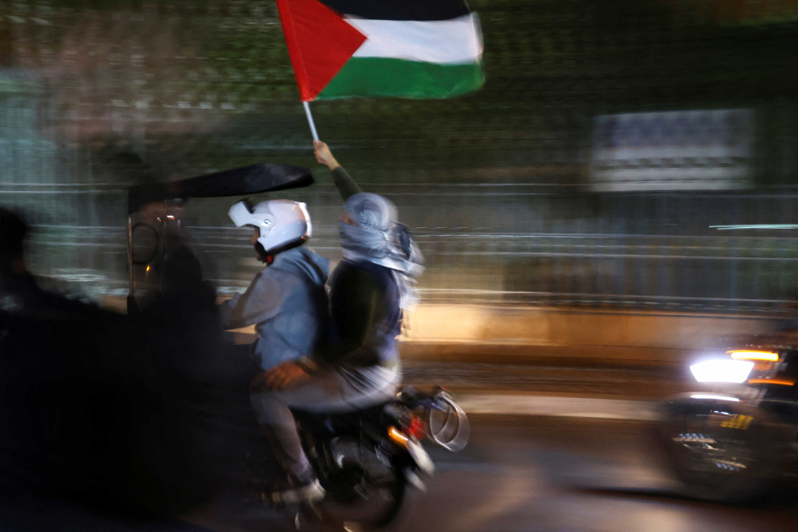 Protesters ride on a motorcycle as they carry a Palestinian flag during an anti-Israel protest in front of the French embassy in Tehran, Iran, October 18, 2023. Majid Asgaripour