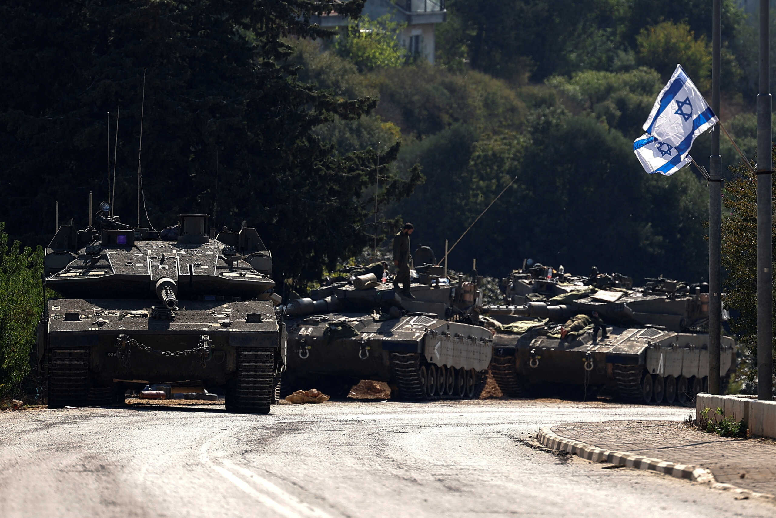 FILE PHOTO: Israeli tanks are seen on a road near Israel's border with Lebanon, in northern Israel, October 12, 2023. REUTERS