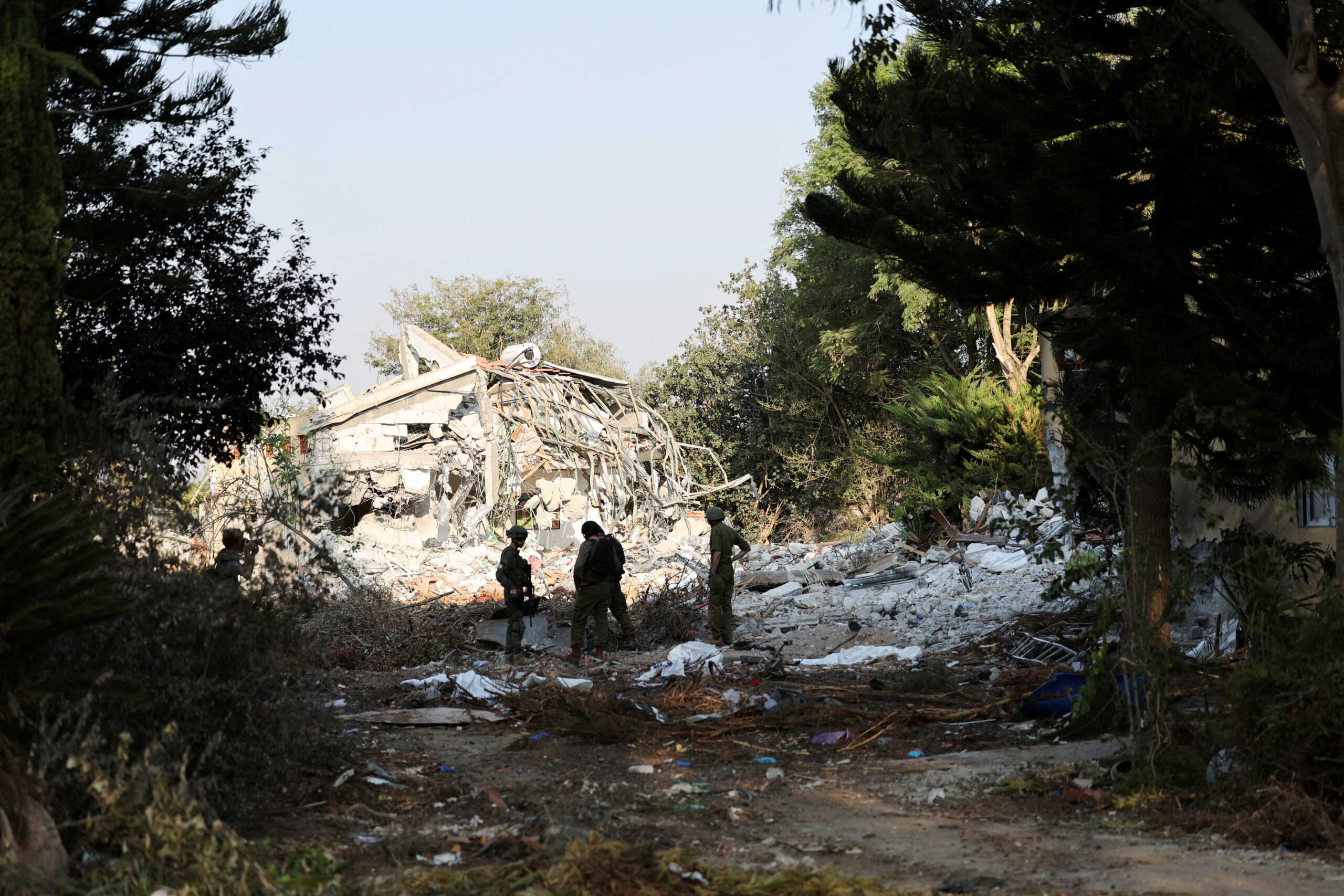 Israeli soldiers stand, in the aftermath of a mass infiltration by Hamas gunmen from the Gaza Strip, in Kibbutz Beeri in southern Israel, October 14, 2023. REUTERS
