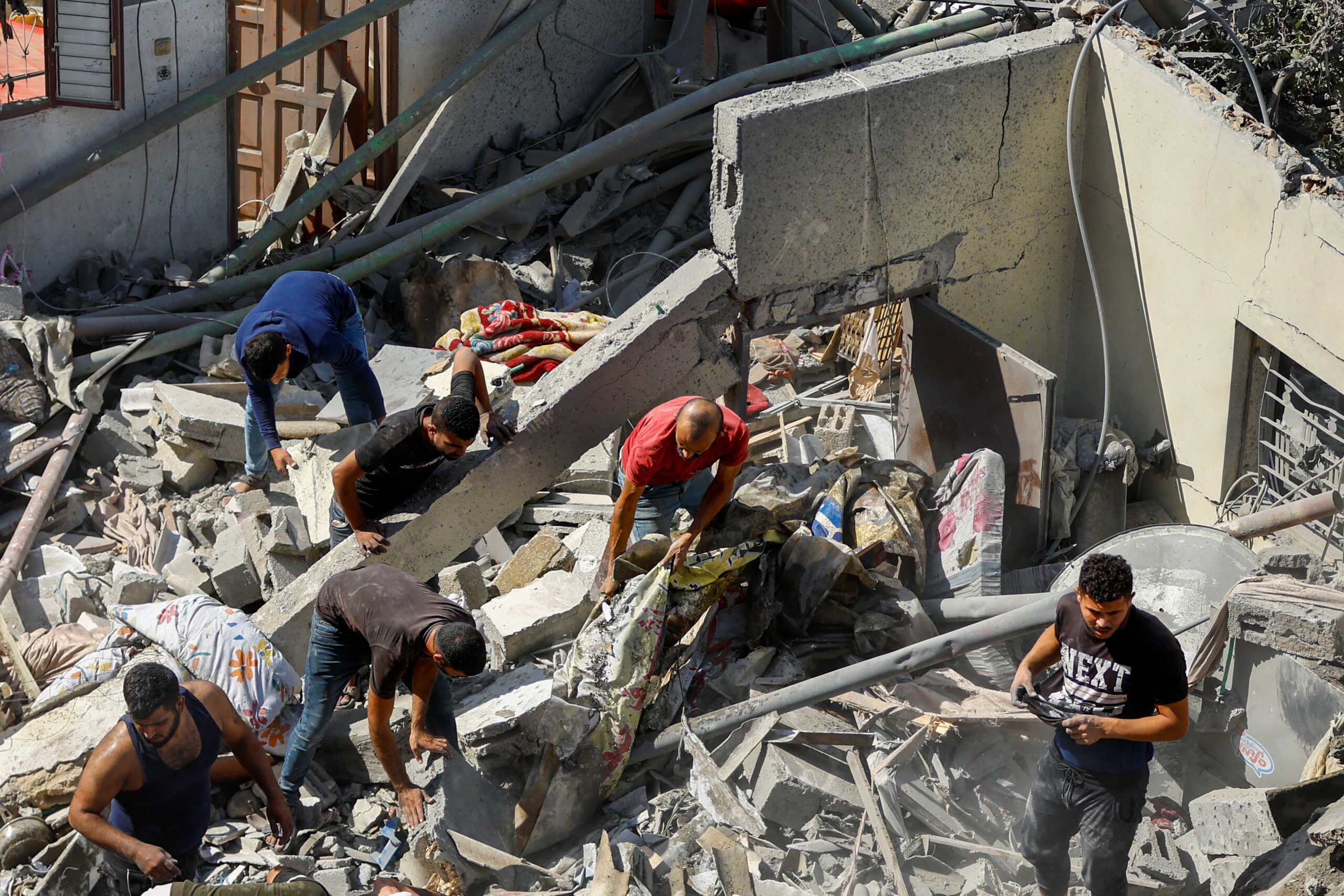 Palestinians search for casualties at the site of Israeli strikes on houses in Rafah in the southern Gaza Strip October 17, 2023. REUTERS
