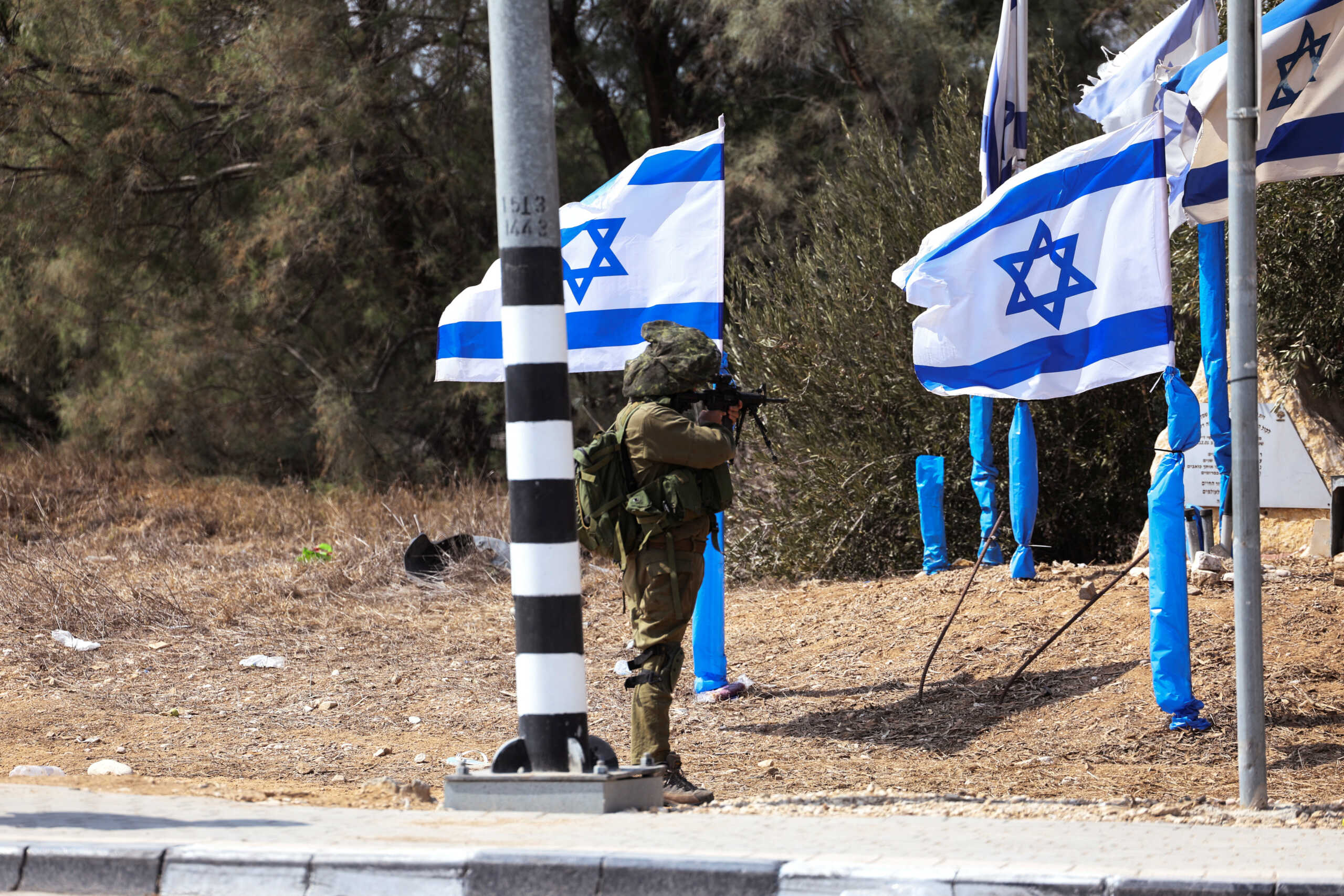 An Israeli soldier stands in position at the entrance to Kibbutz Kfar Aza, in southern Israel, October 10, 2023. REUTERS