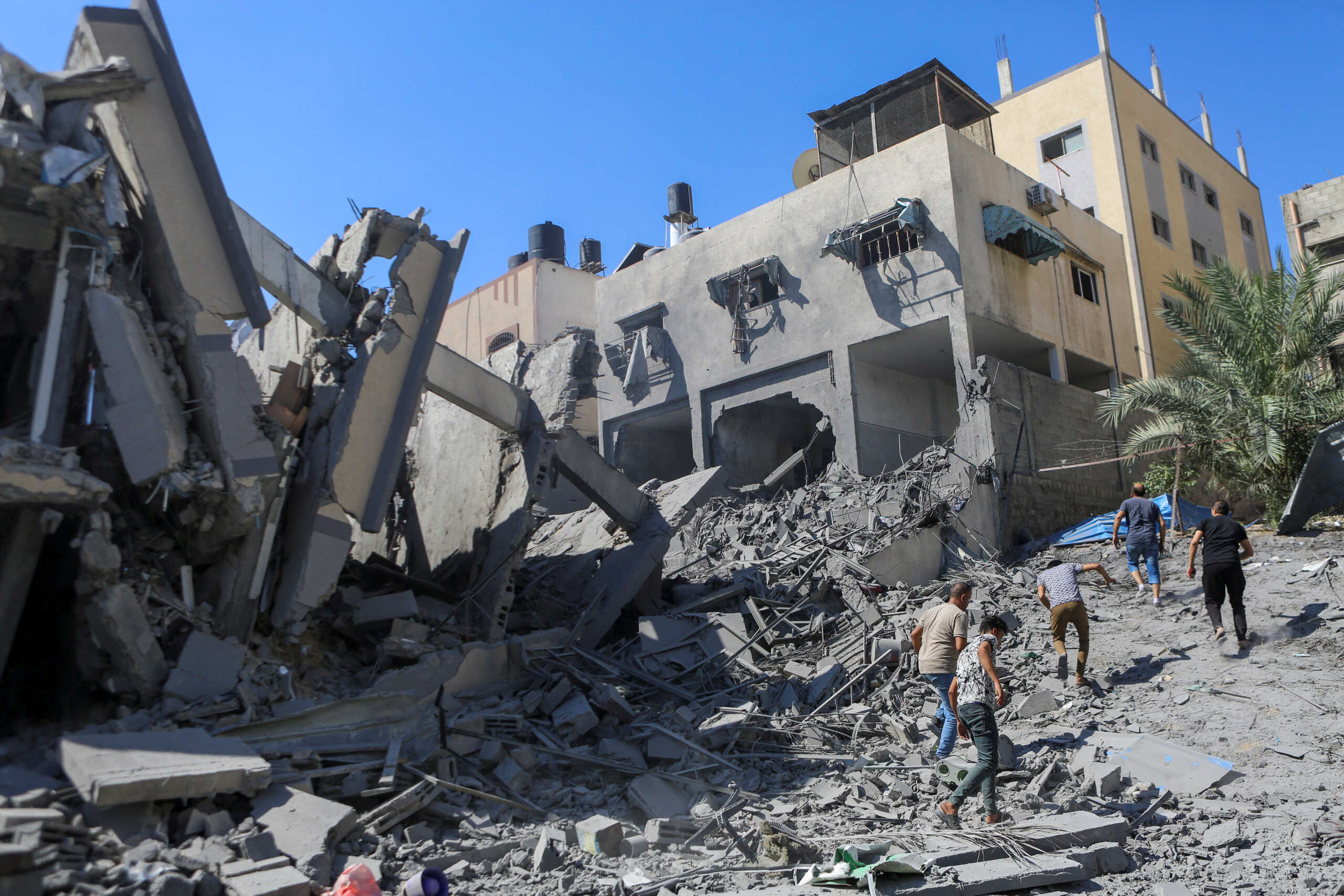 Palestinians run past the rubble following Israeli strikes in Gaza City October 15, 2023. REUTERS