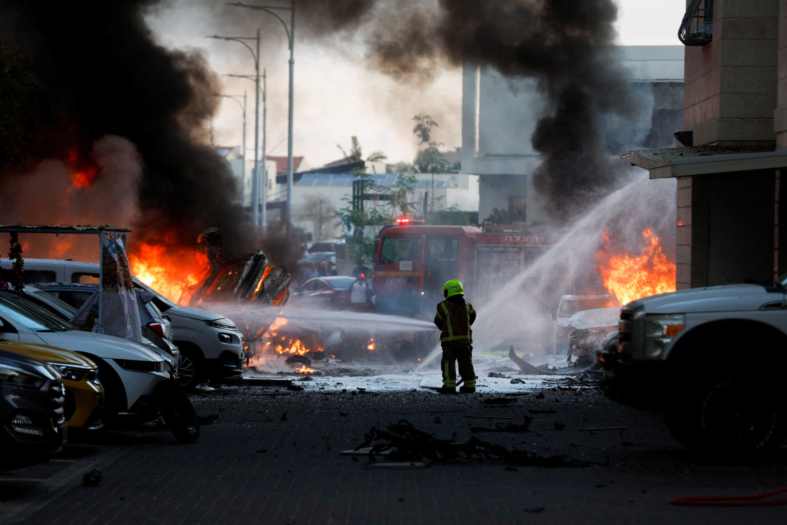 An emergency personnel works to extinguish fire after rockets launched from the Gaza Strip, as seen from the city of Ashkelon, Israel October 7, 2023. REUTERS