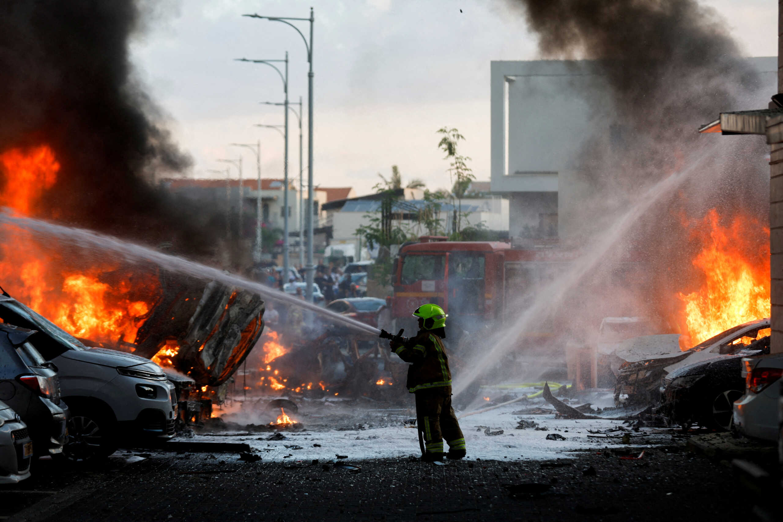 FILE PHOTO: An emergency personnel works to extinguish the fire after rockets are launched from the Gaza Strip, as seen from the city of Ashkelon, Israel October 7, 2023. REUTERS