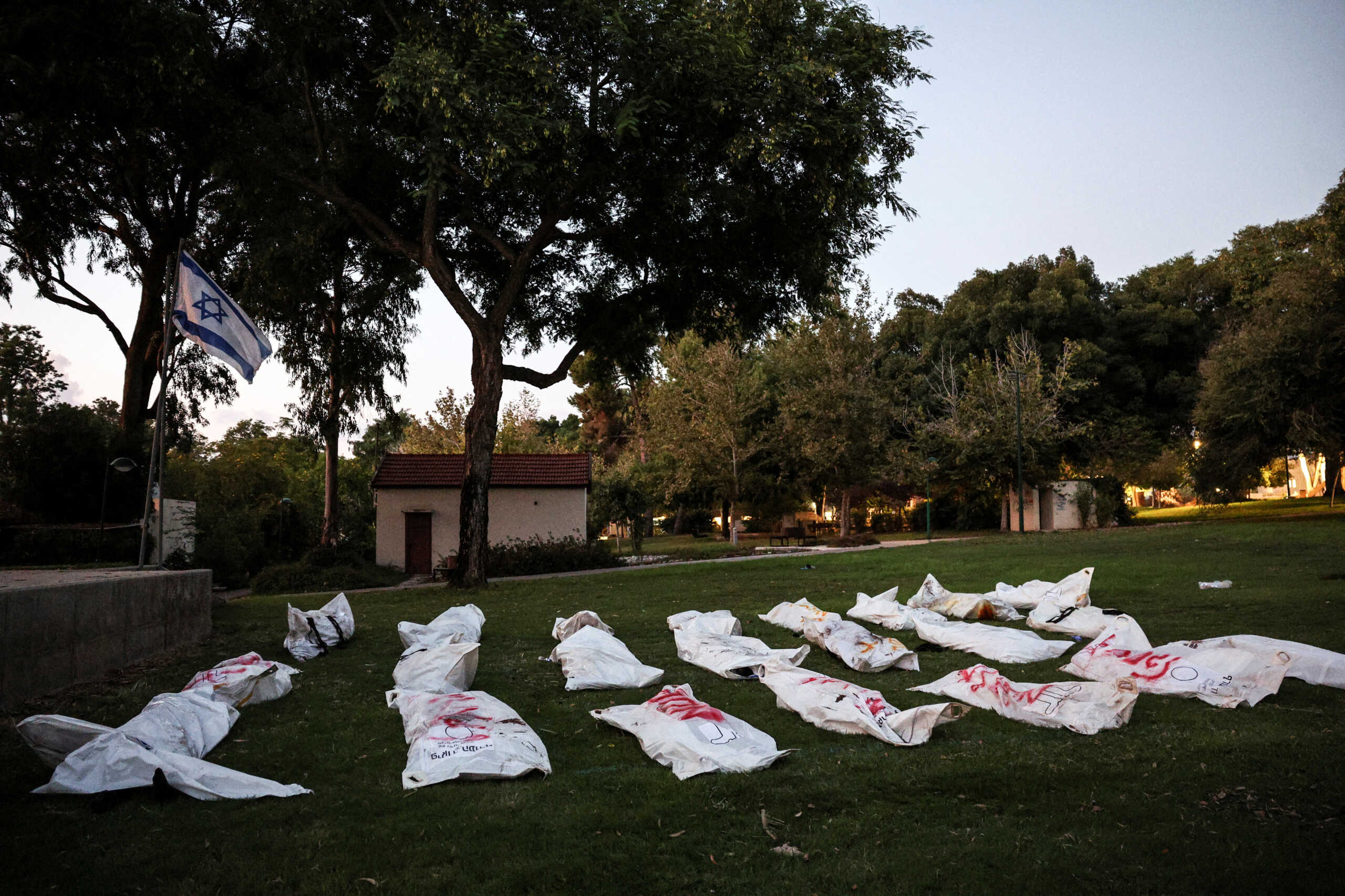 The dead bodies of Palestinians lie on grass following a mass infiltration by Hamas gunmen from the Gaza Strip, in Kibbutz Beeri in southern Israel, October 11, 2023. REUTERS