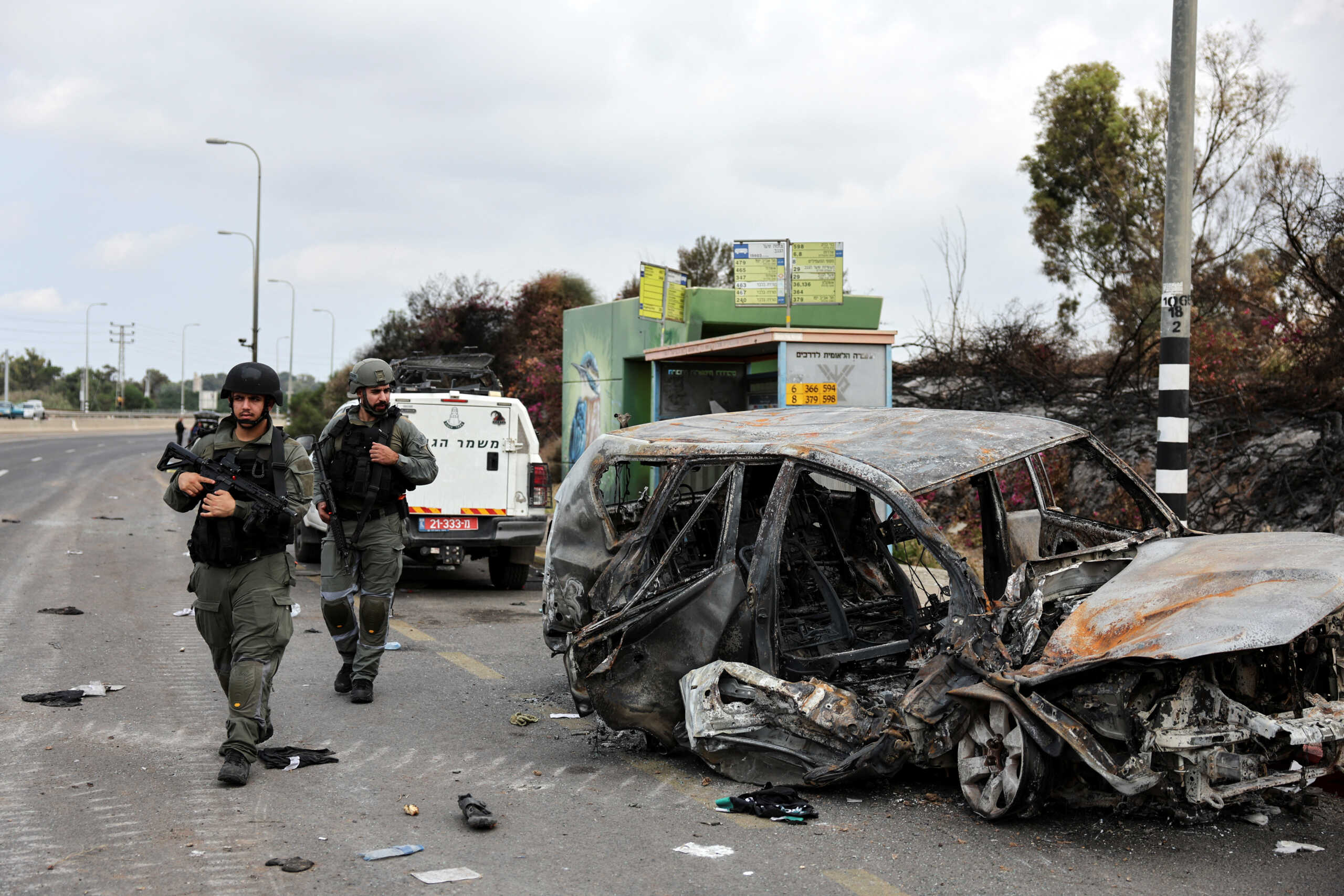 Israeli border police walk past a burnt out car as rockets are launched from the Gaza Strip towards Israel, in Ashkelon, southern Israel October 10, 2023. REUTERS