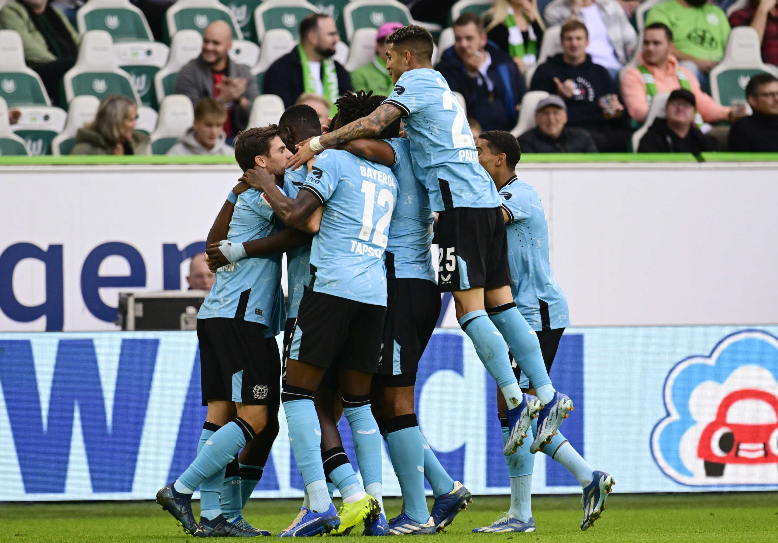 Soccer Football - Bundesliga - VfL Wolfsburg v Bayer Leverkusen - Volkswagen Arena, Wolfsburg, Germany - October 21, 2023 Bayer Leverkusen's Jeremie Frimpong celebrates scoring their first goal with teammates REUTERS
