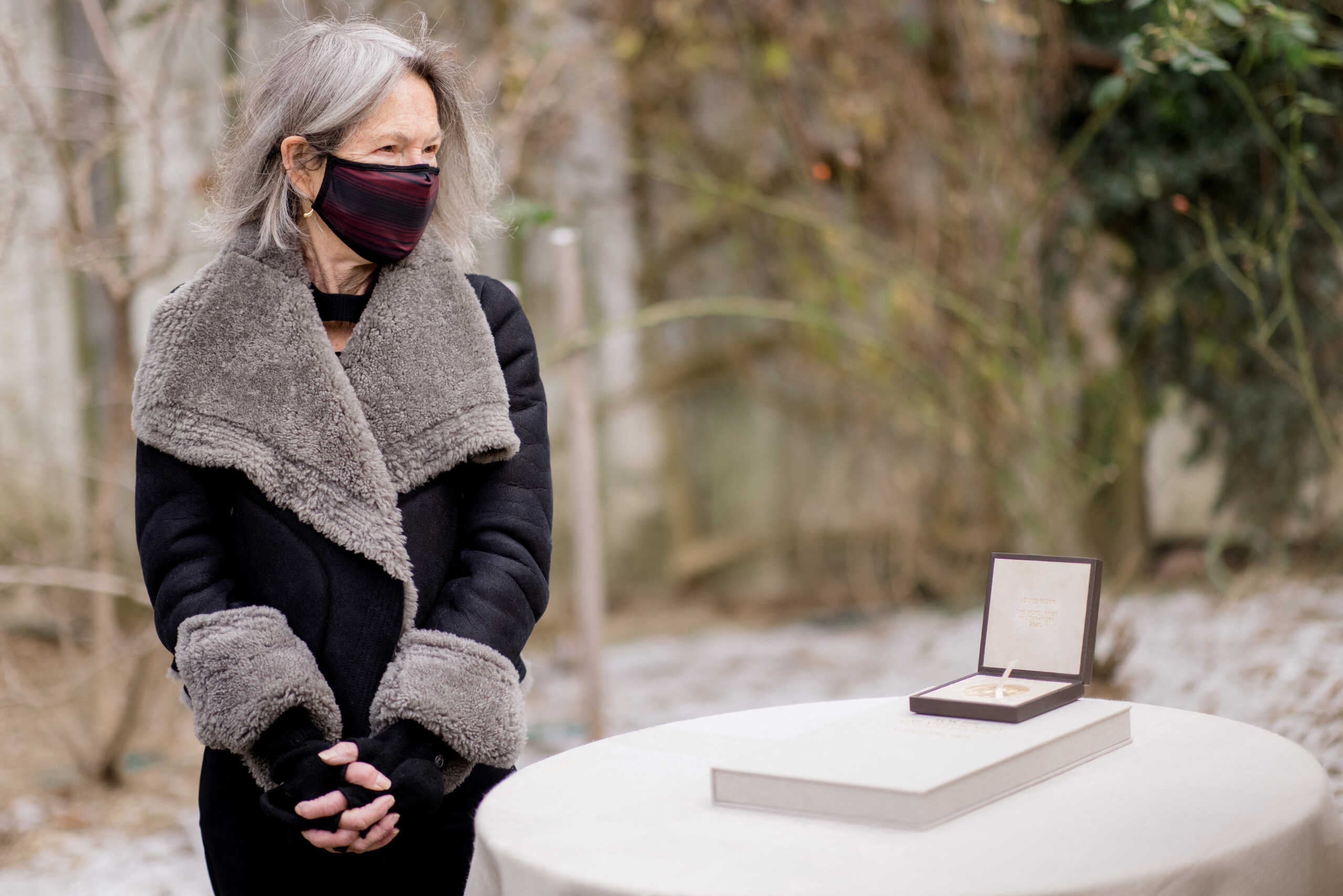 FILE PHOTO: American poet Louise Gluck poses with her 2020 Nobel Prize for Literature medal and diploma outside her home in Cambridge, Massachusetts, U.S., in this undated handout image obtained by Reuters on December 7, 2020. Nobel Prize Outreach