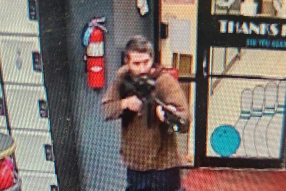 A man identified as a suspect by police points what appears to be a semiautomatic rifle, in Lewiston, Maine, U.S., October 25, 2023.    Androscoggin County Sheriff’s Office via Facebook
