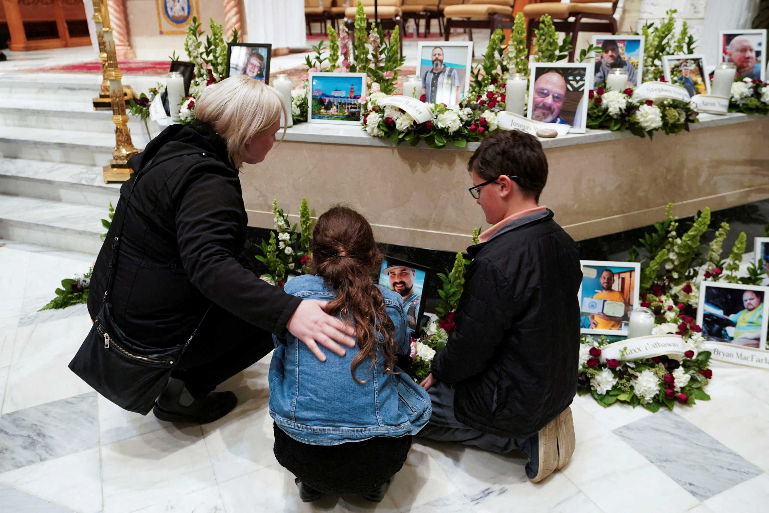 FILE PHOTO: Mourners look at pictures of the victims during a vigil for the victims of the deadly mass shooting, at the Basilica of Saints Peter and Paul, in Lewiston, Maine, U.S., October 29, 2023. REUTERS