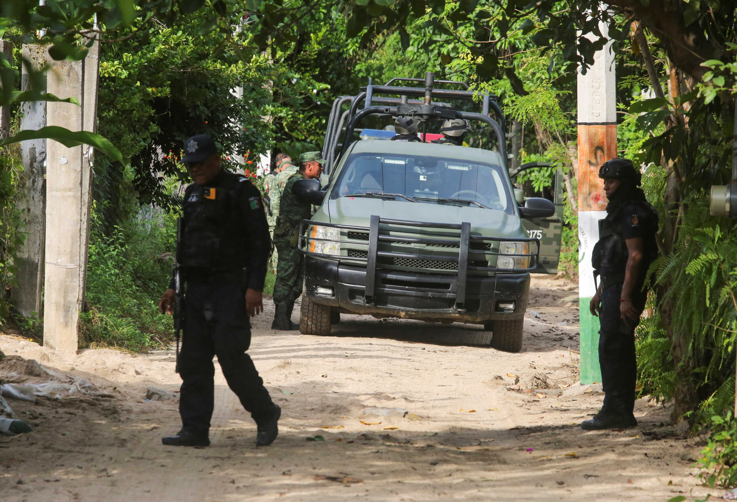 Mexican armed forces stand guard near a crime scene where several local police officers were shot dead by gunmen, in Coyuca de Benitez, Mexico October 23, 2023. REUTERS