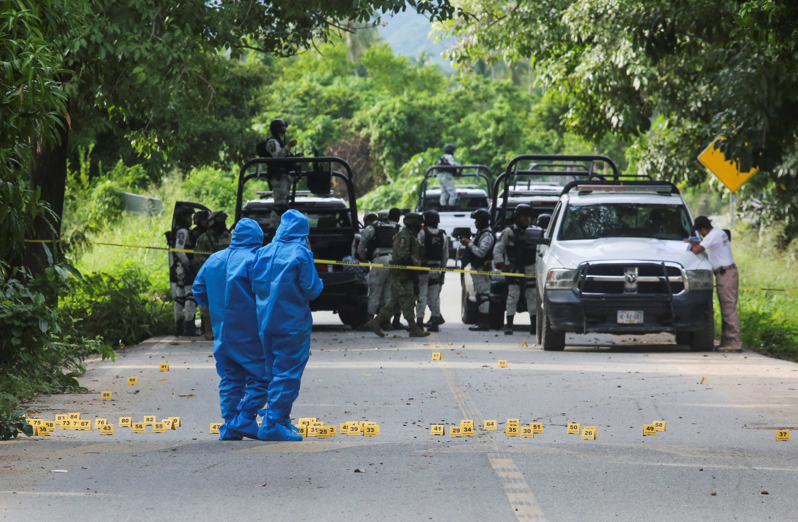 Forensic technicians work at a crime scene where several local police officers were shot dead by gunmen, in Coyuca de Benitez, Mexico October 23, 2023. REUTERS